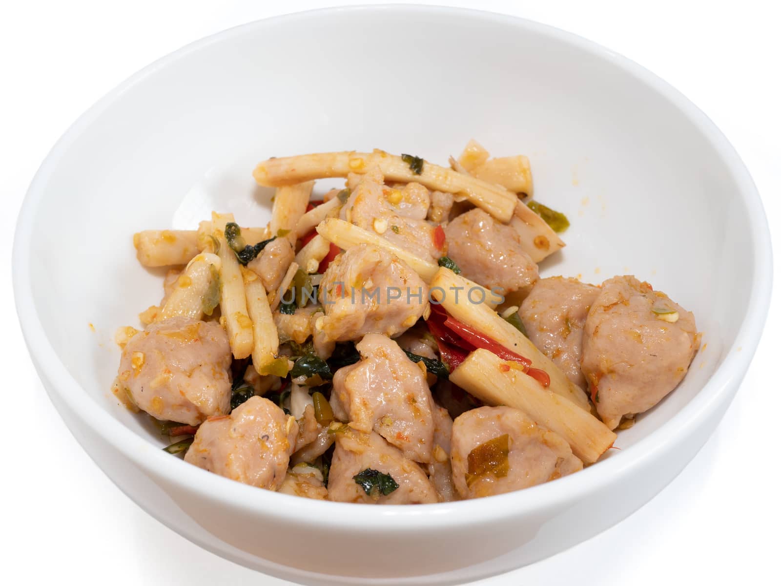 The close up of Fried Spicy Bamboo Shoot With fish ball (Thai food) in white bowl on white background.