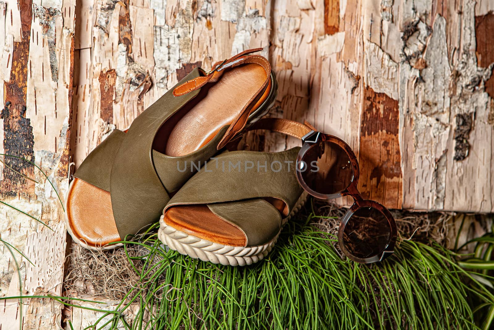 Different shoes with accessories on a studio background