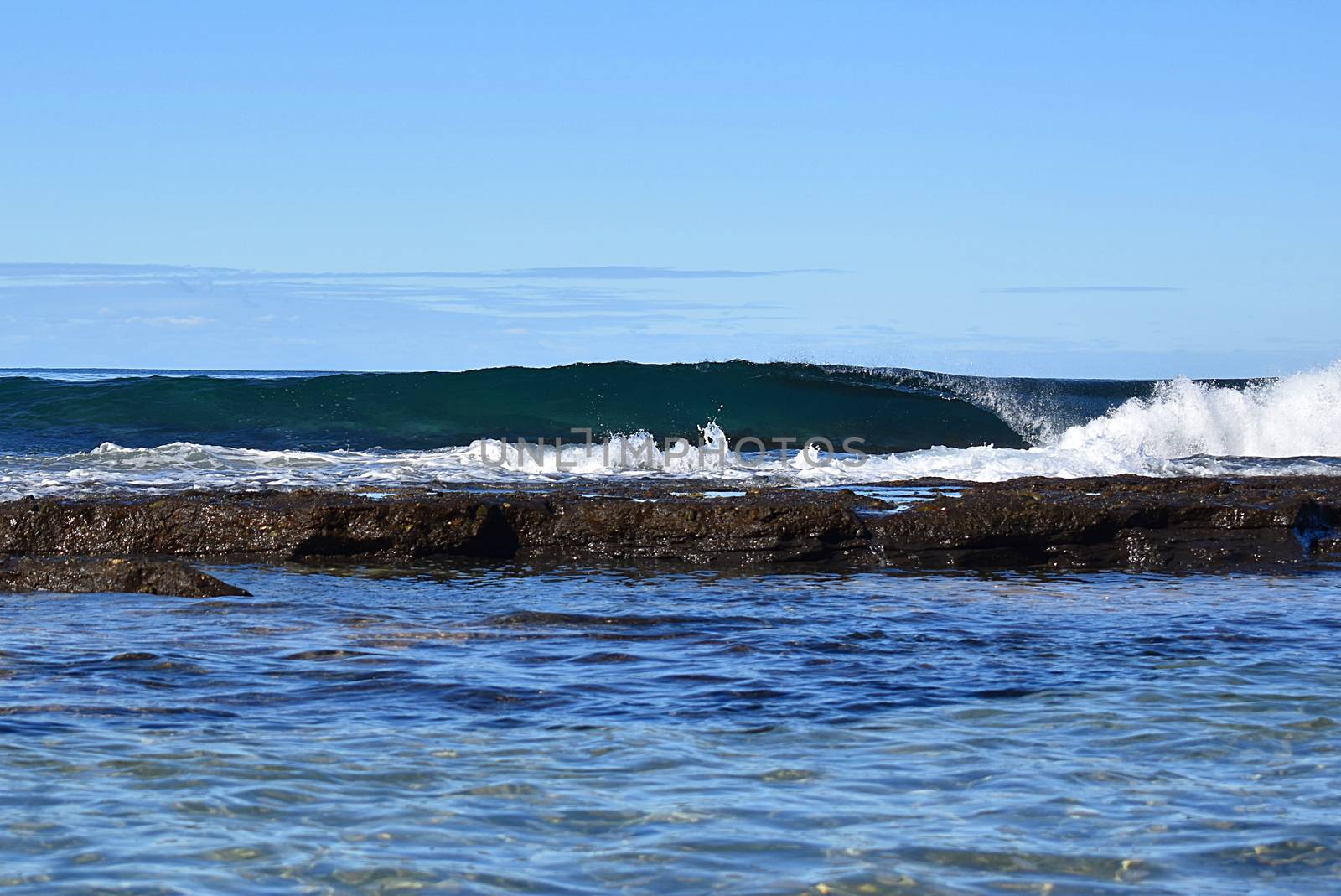 Beach with a crashing wave and rocks