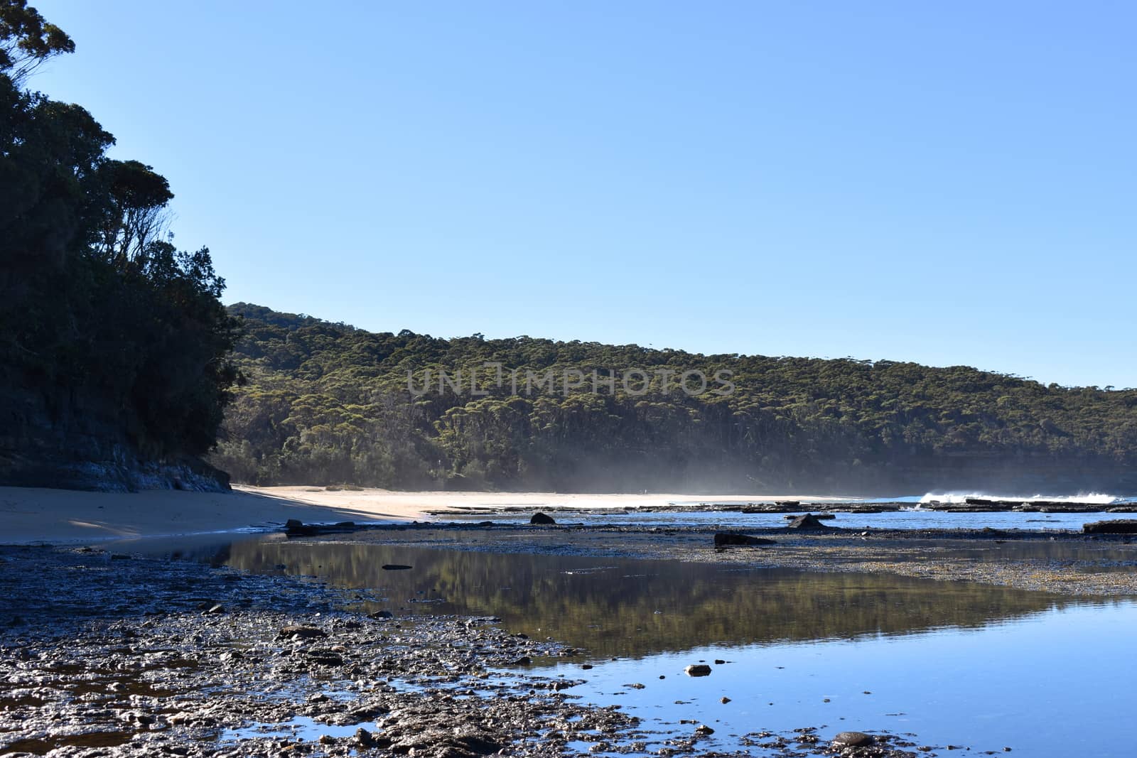 A beach with cliffs and mountains