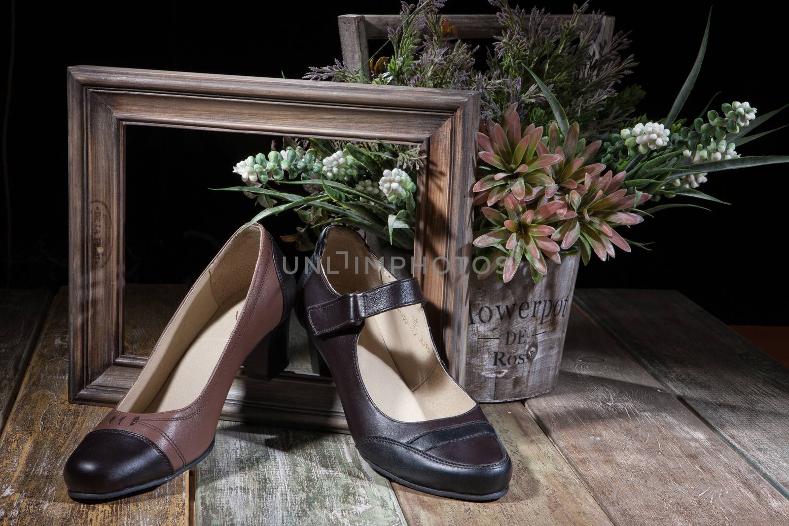 Different kinds of shoes on a wooden desk