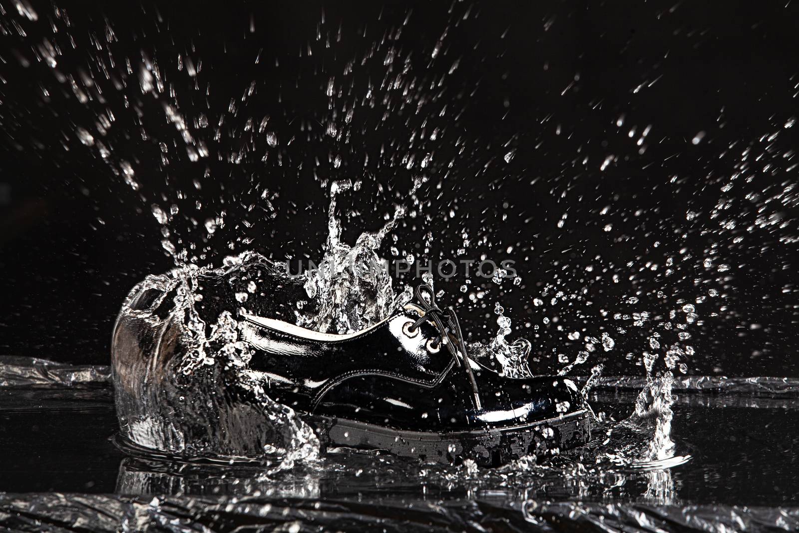 Shoe falling into the water on a studio background