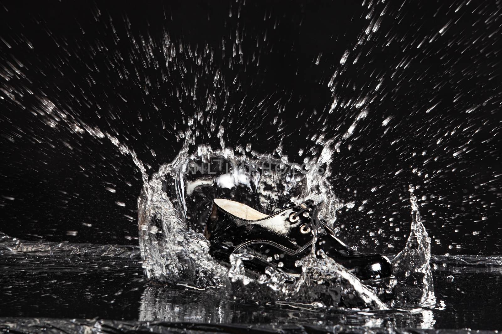 Shoe falling into the water on a studio background