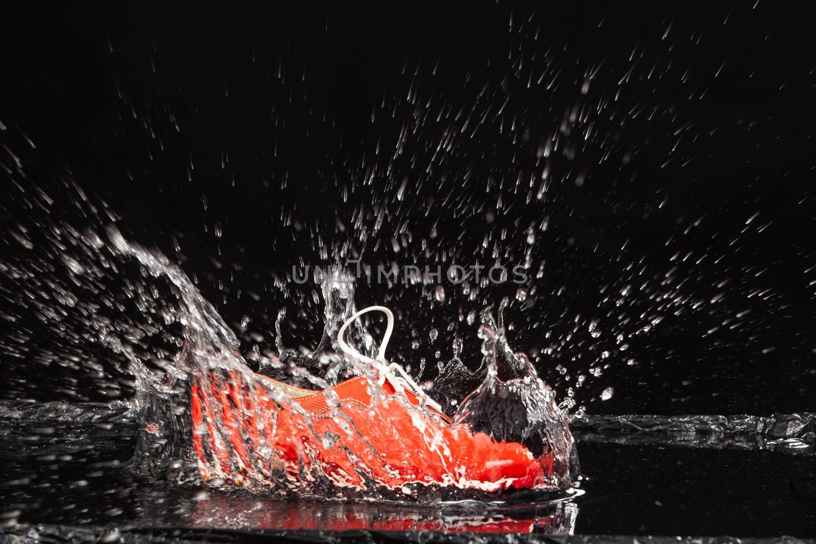 Shoe falling into the water on a studio background