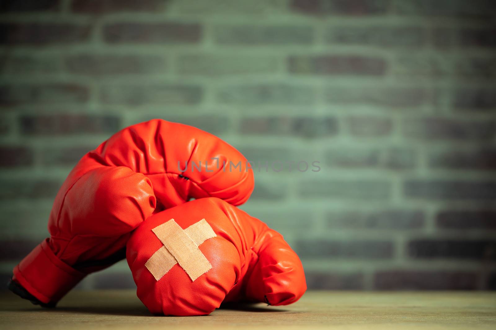 Red boxing gloves on wooden table and brick wall at sport gym. by SaitanSainam