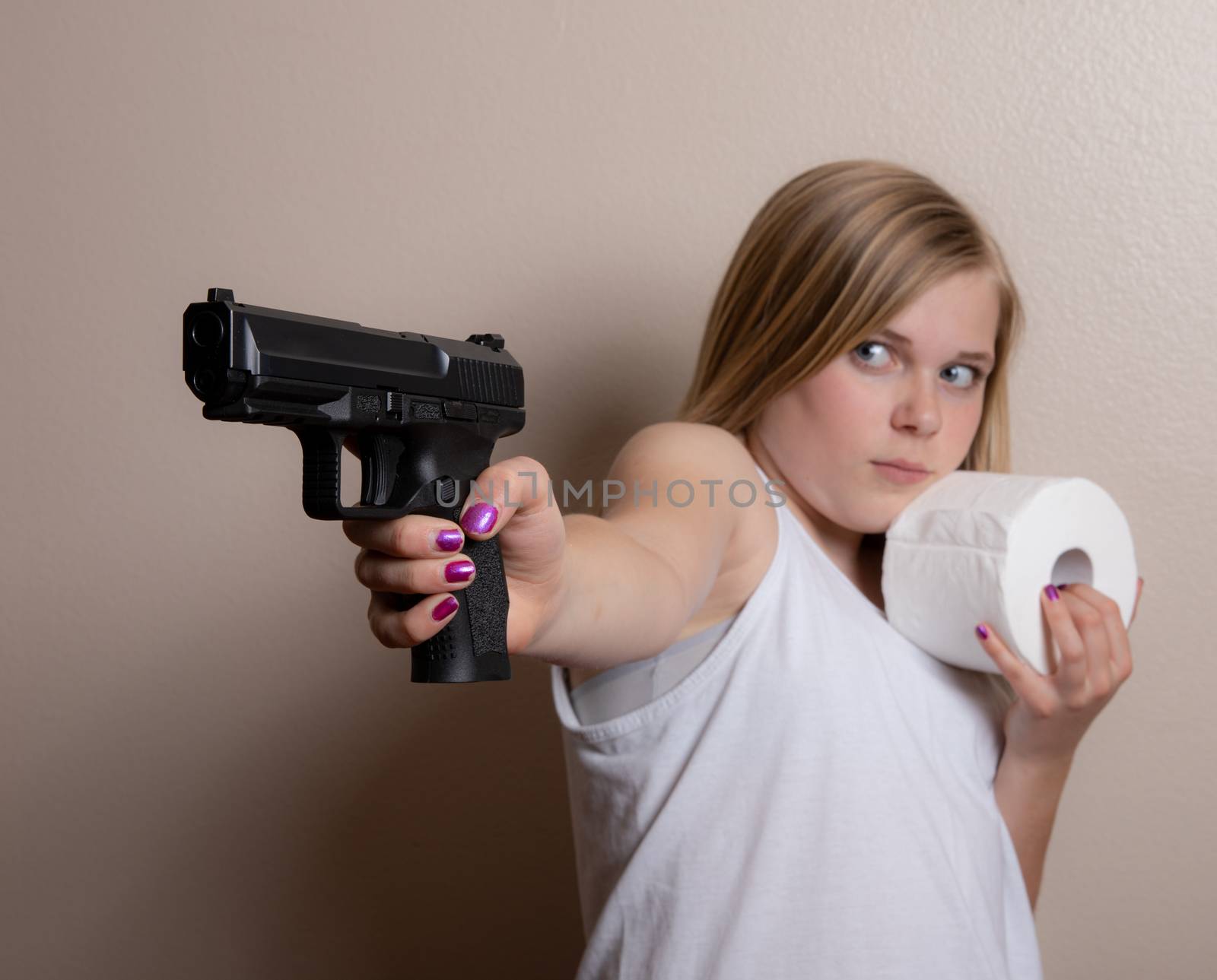 Young girl holds a gun in one hand and her toilet paper in the other