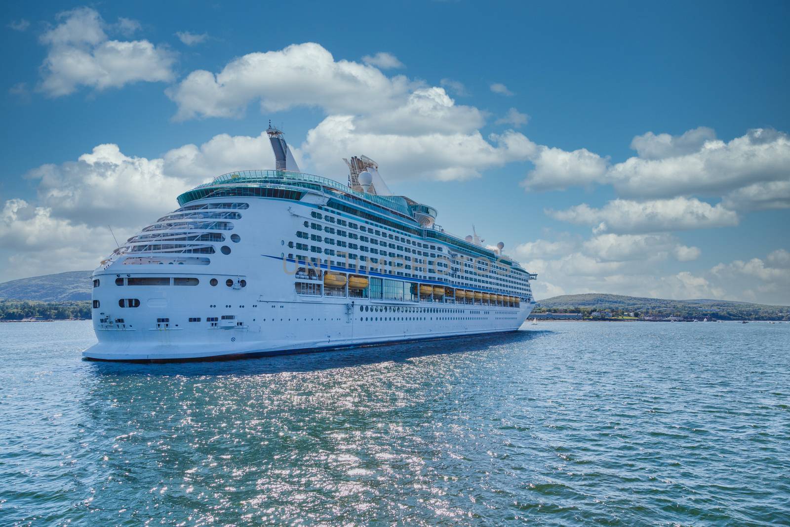 Huge, white, luxury cruise ship anchored in blue water