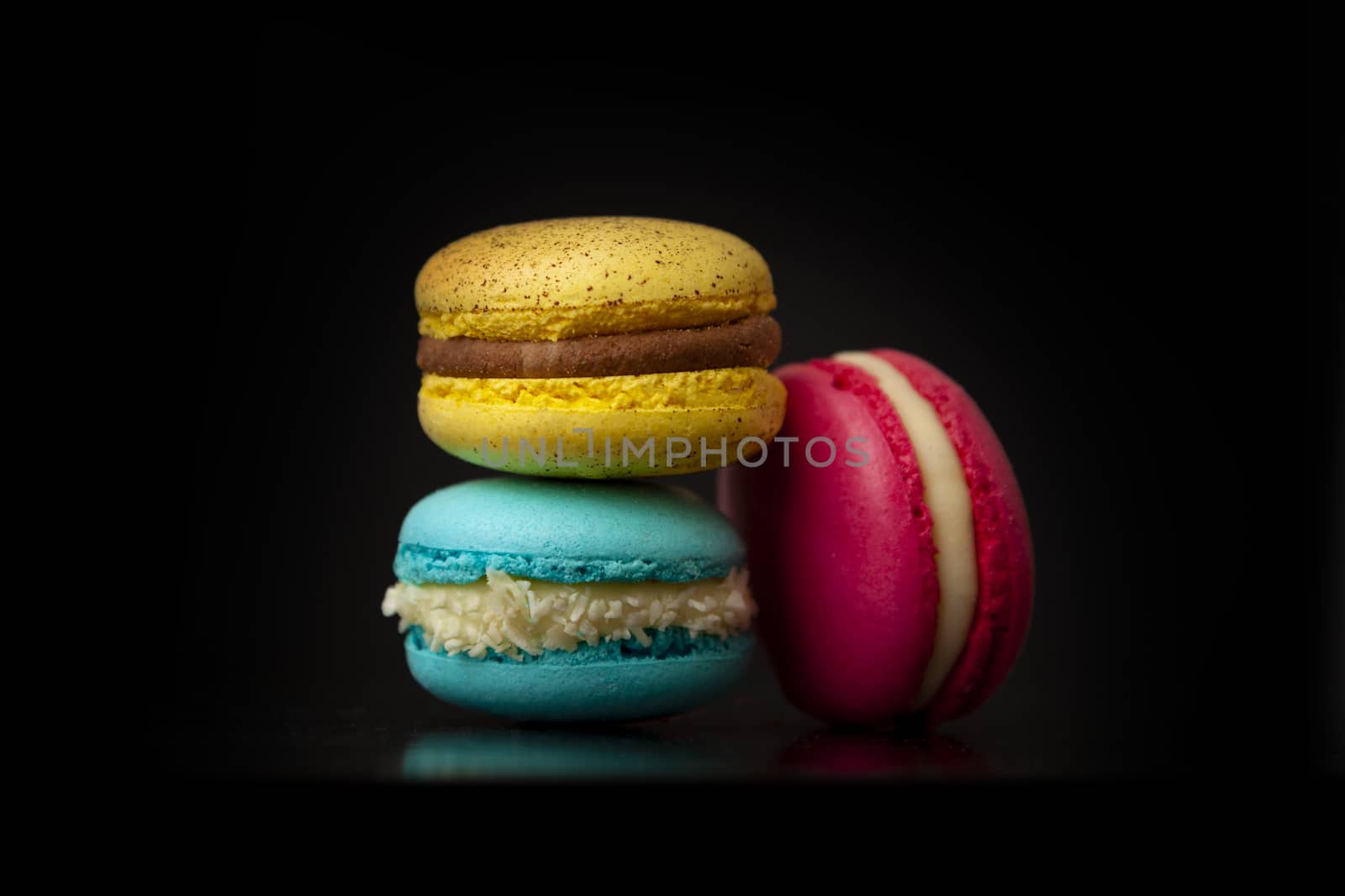 Colorful macarons cakes. Small French cakes. Sweet and colorful french macaroons isolated on black background