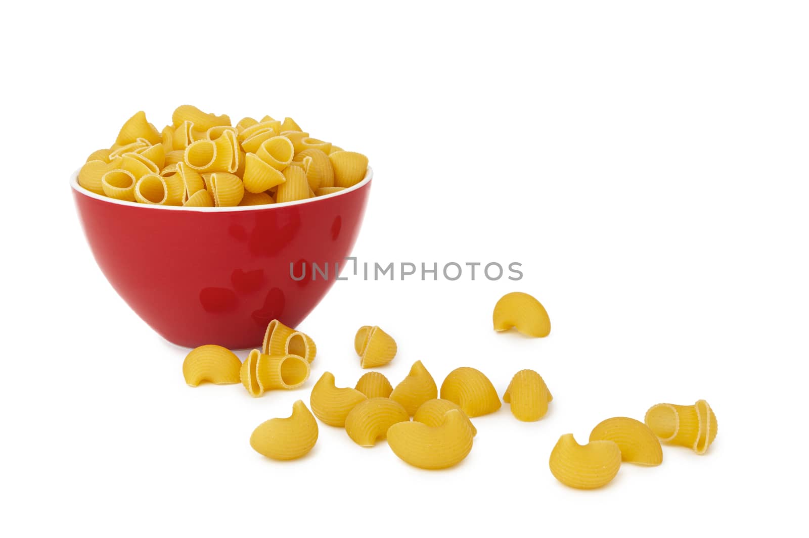 Pasta Pipe Rigate in a red bowl. Isolated on a white background