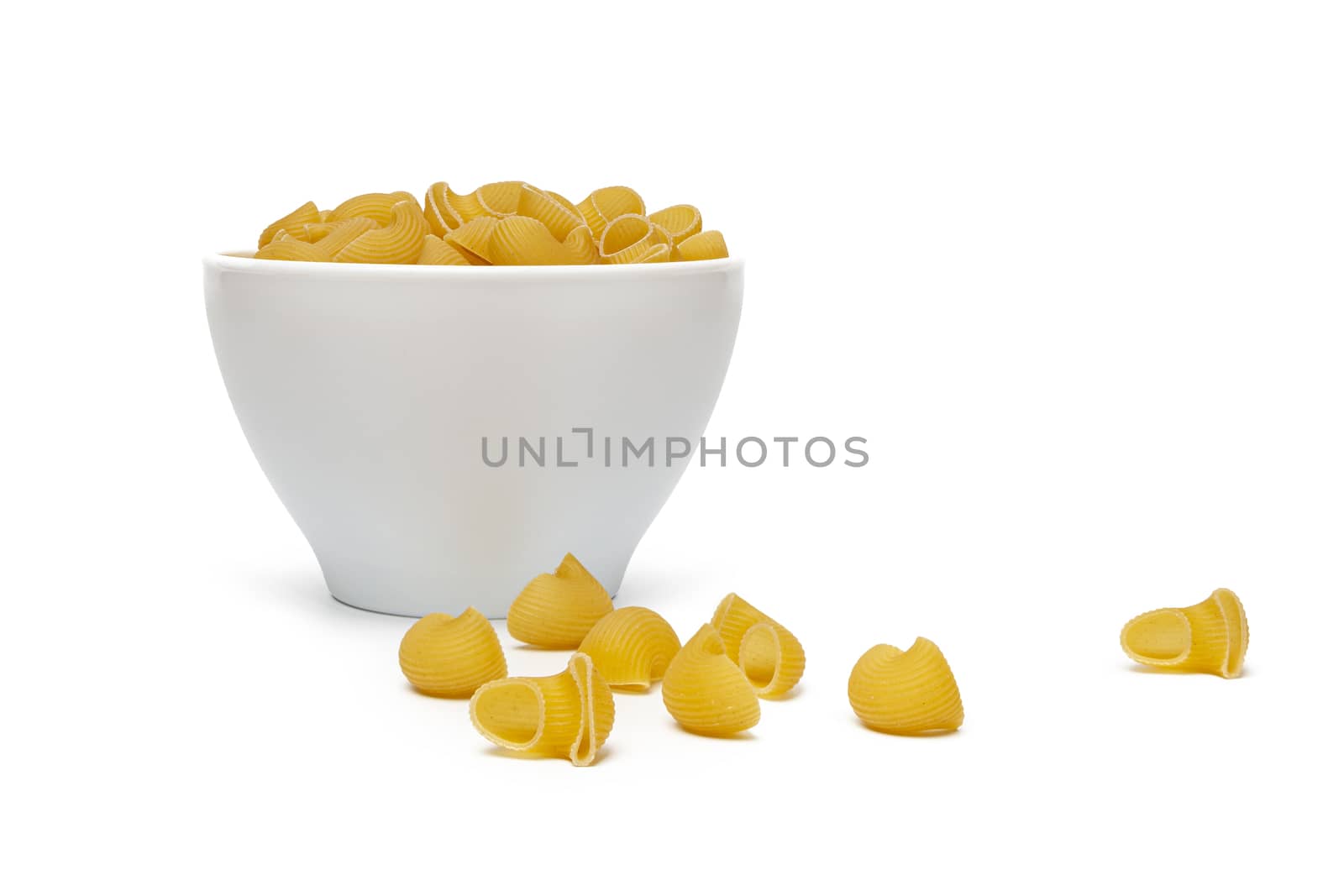 Pasta Pipe Rigate in a white bowl. Isolated on a white background