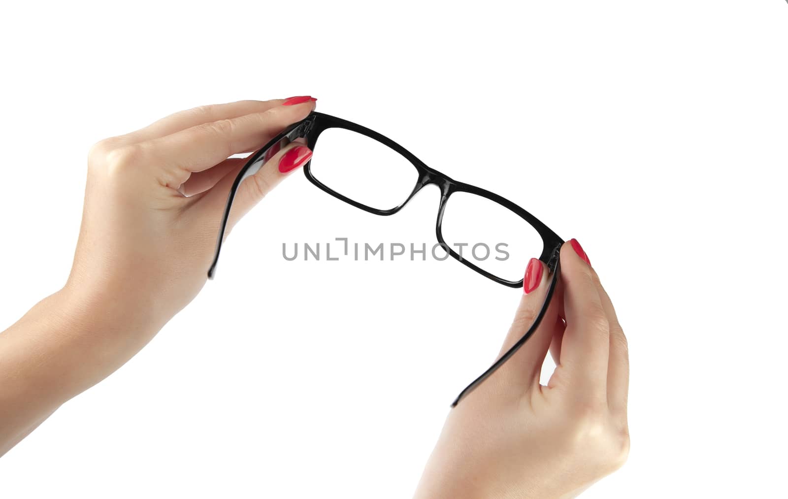 Female hand holding a black-framed glasses isolated on white background