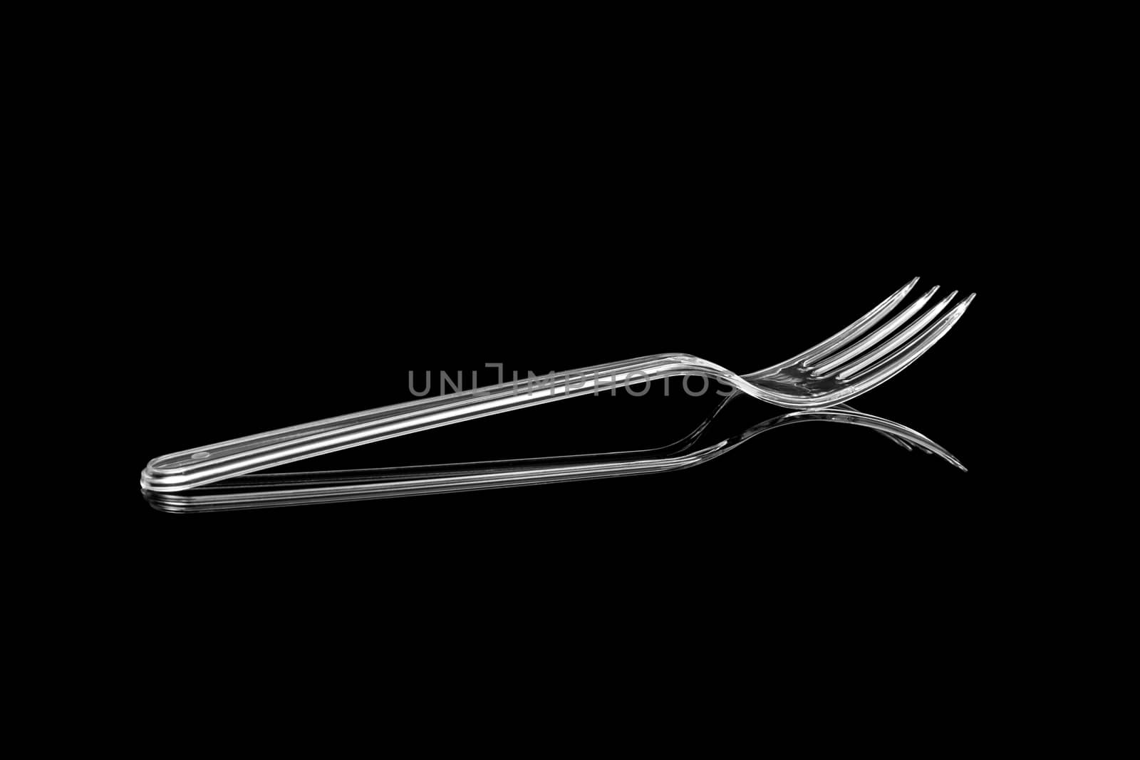 Transparent plastic fork isolated on black background by SlayCer