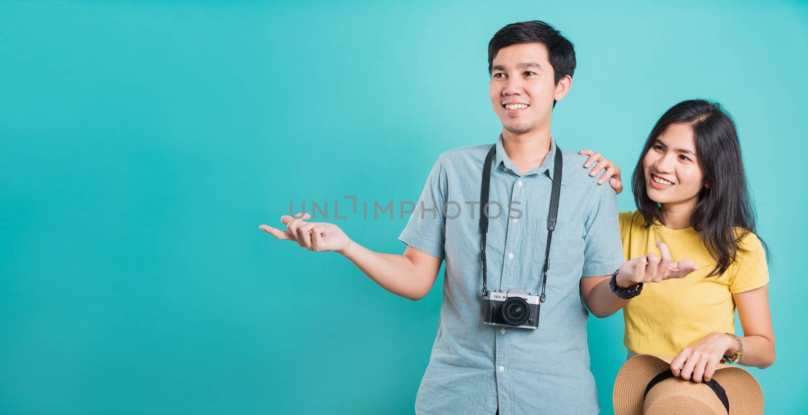 Happy Asian couple young beautiful woman handsome man smiling white teeth with camera in surprise summer holiday travel tourists isolated on blue background with copy space for text