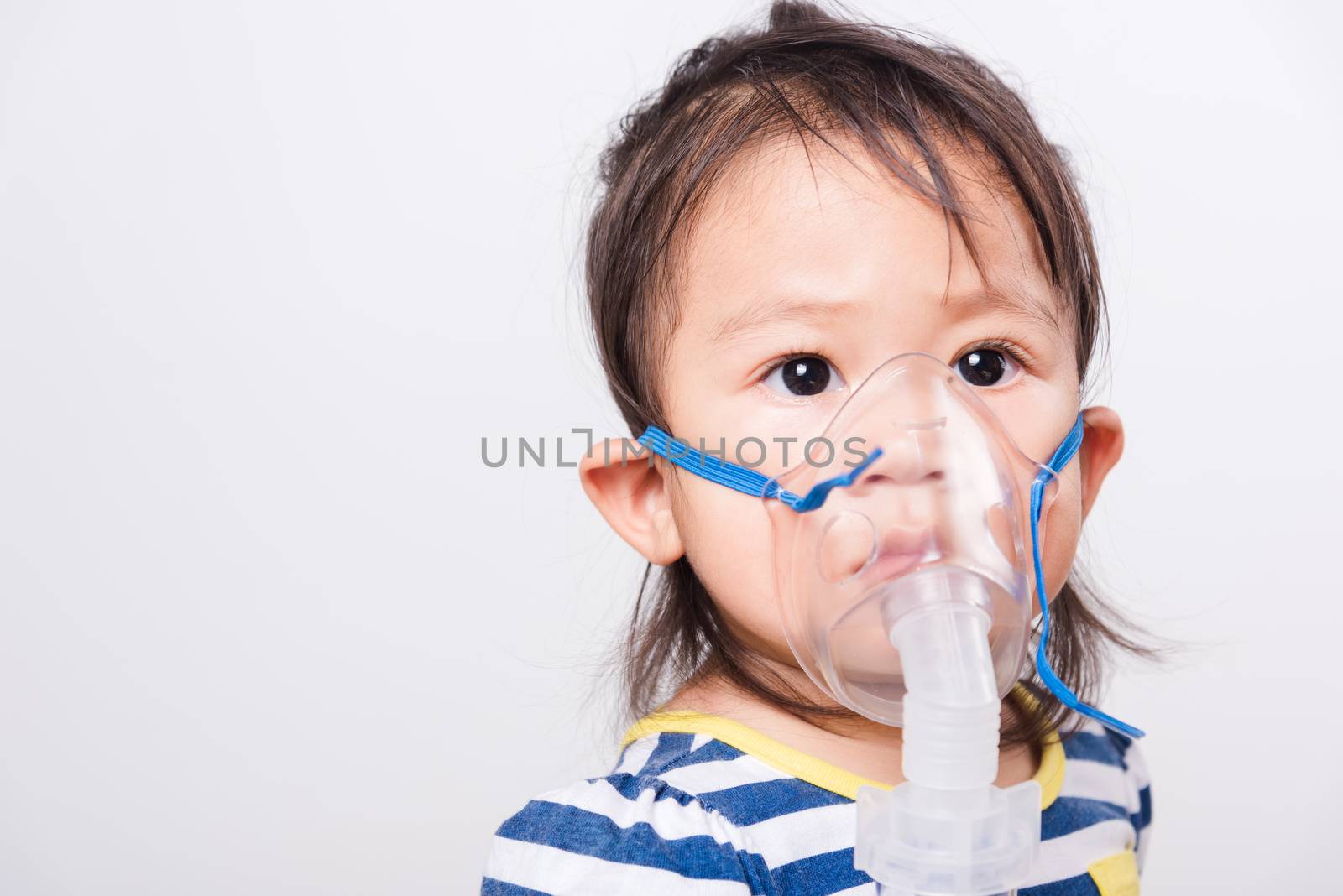 Closeup Asian face, Little baby girl sick her using steam inhaler nebulizer mask inhalation oneself on white background with copy space, health medical care