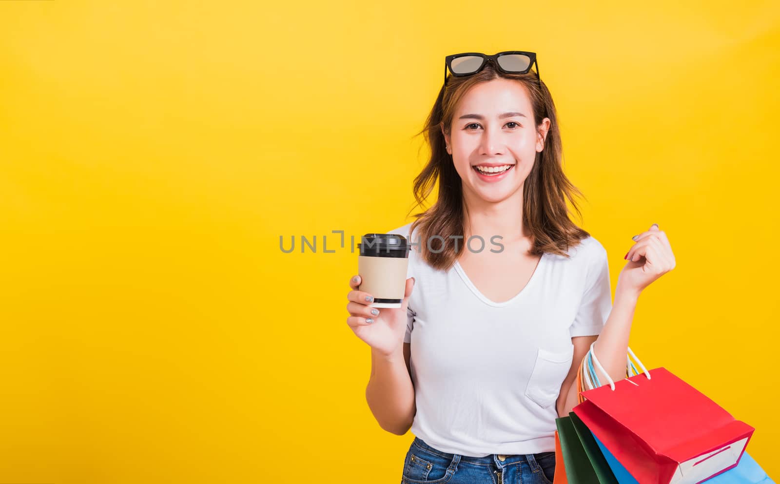 woman smiling hold shopping bags multi-color and take away coffe by Sorapop