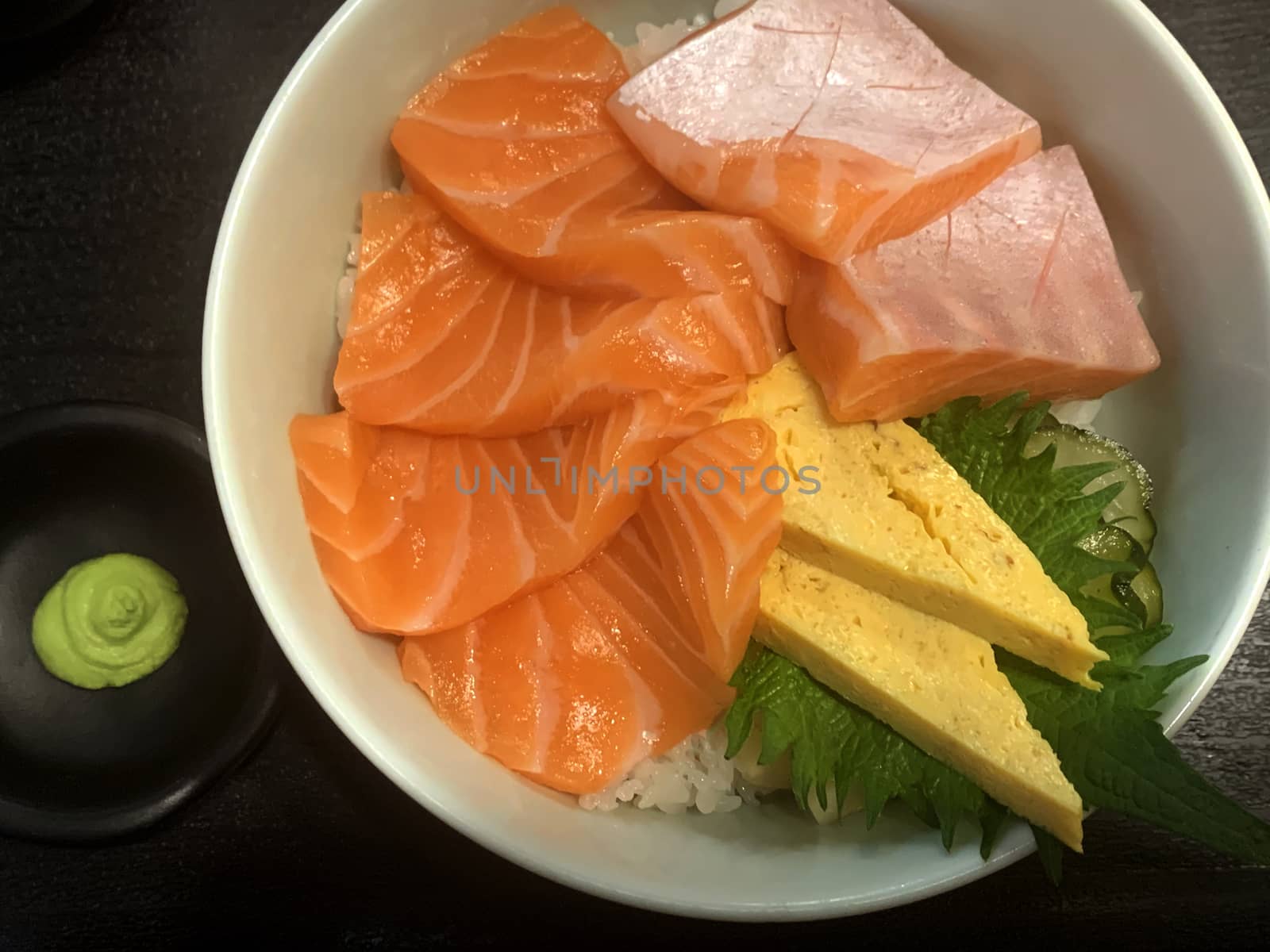 A bowl of Japanese traditional food meal set with sashimi salmon, egg, wasabi