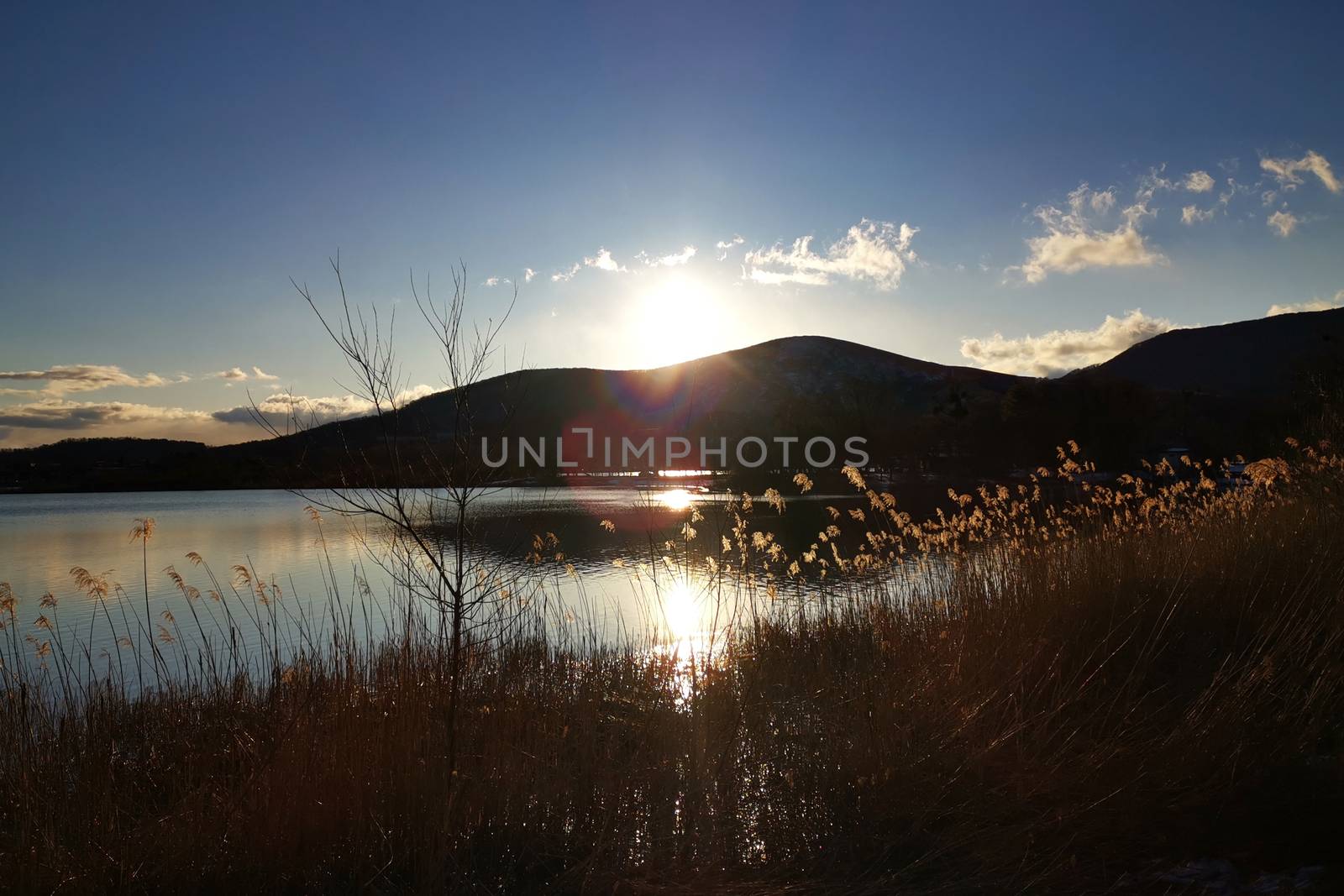 The mountain, lake, blue sky and sun in Japan countryside at sunset