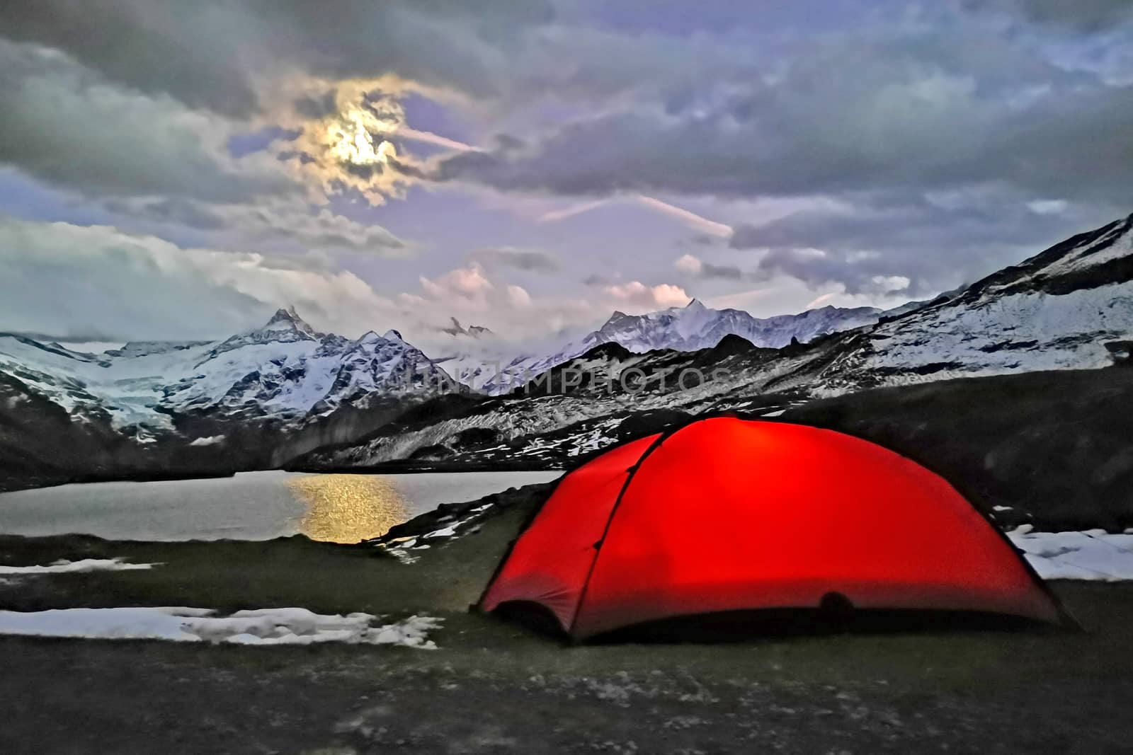 The outdoor camping tent, lake, snow mountain in Switzerland countryside campsite