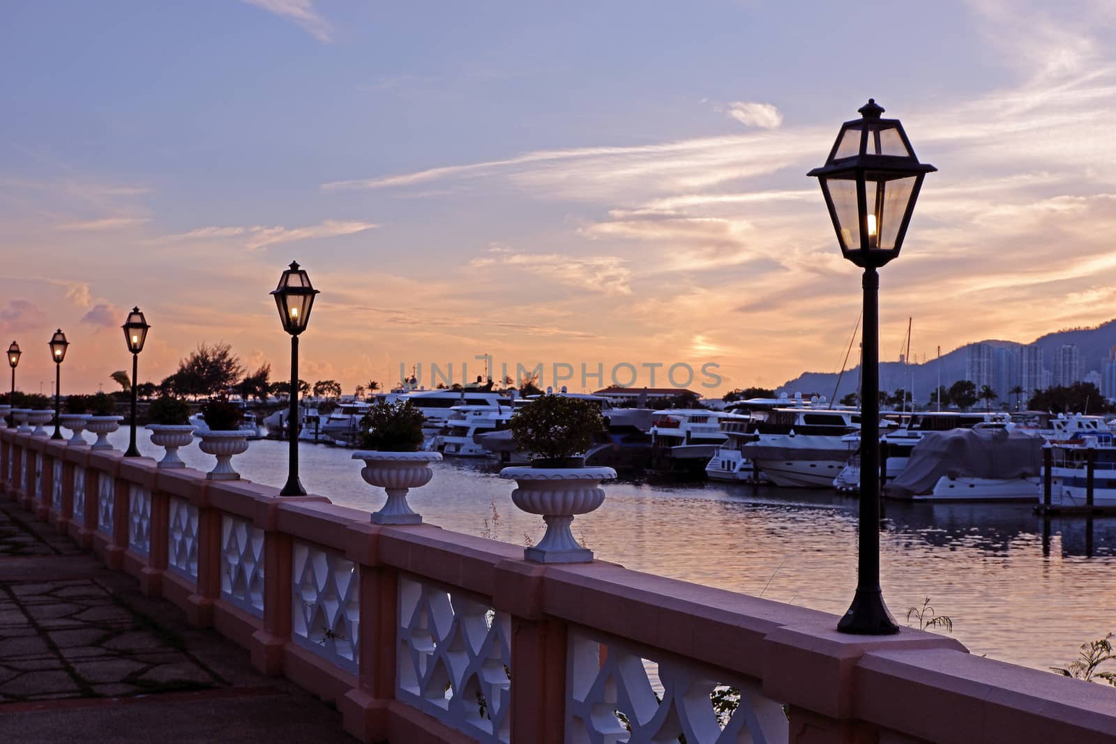 The luxury yacht, footpath, fence and gradient sky at sunset