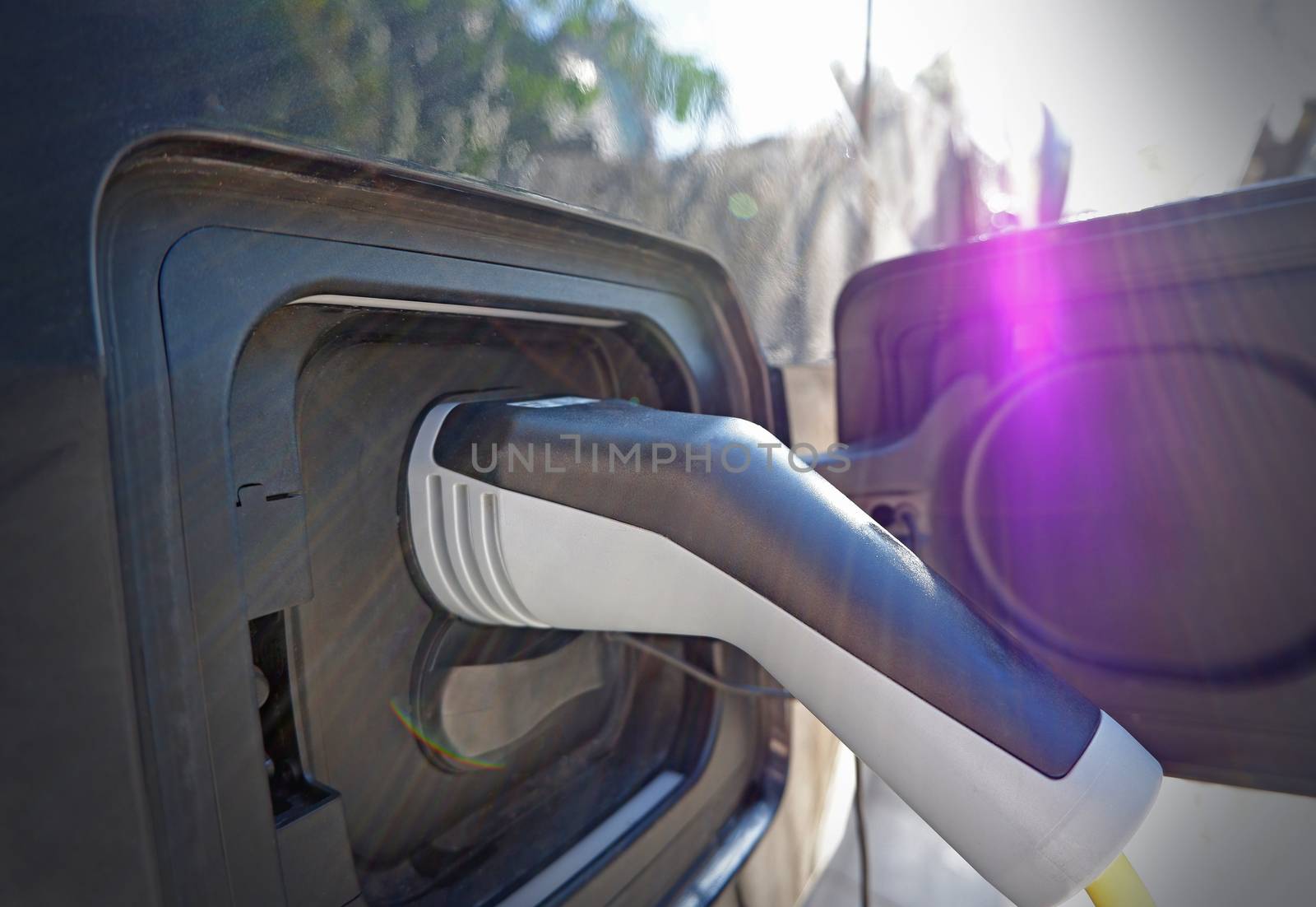 The close up of recharging cable and electric car 