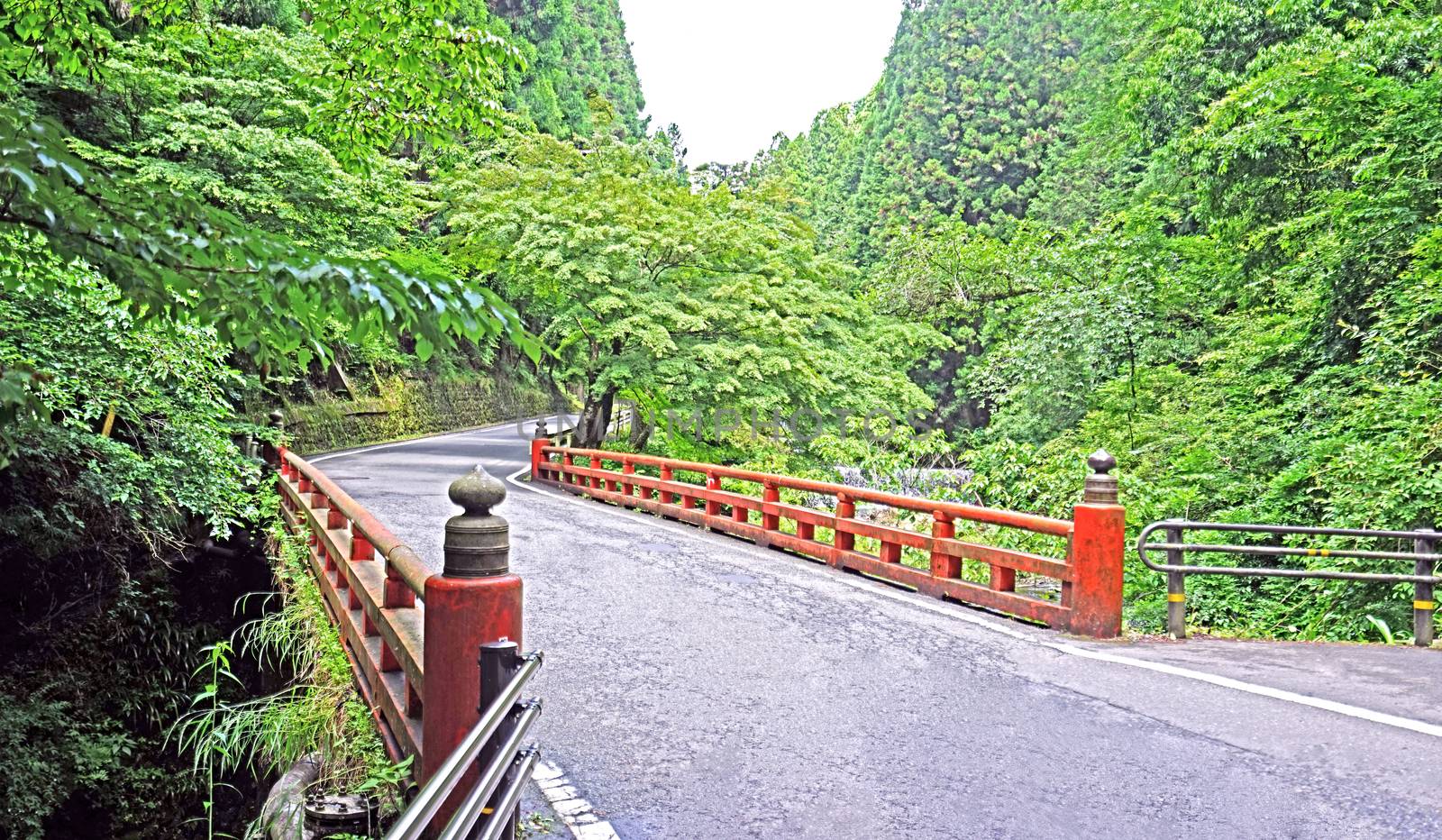 The Japan traditiaonal red bridge and road in mountain by cougarsan