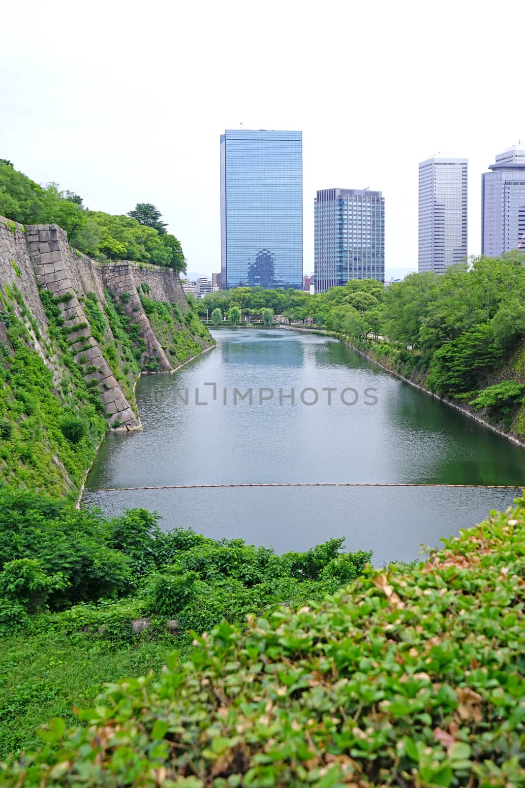 The Japan Osaka landmark historical castle architectural with commerical building in downtown