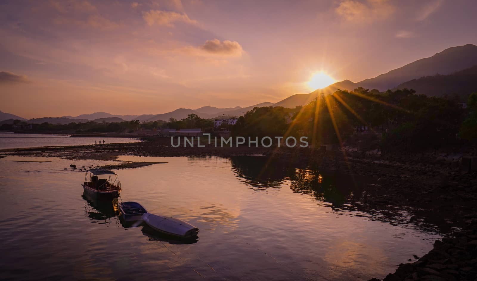 The fishing boat on the lake at sunset with sunlight 