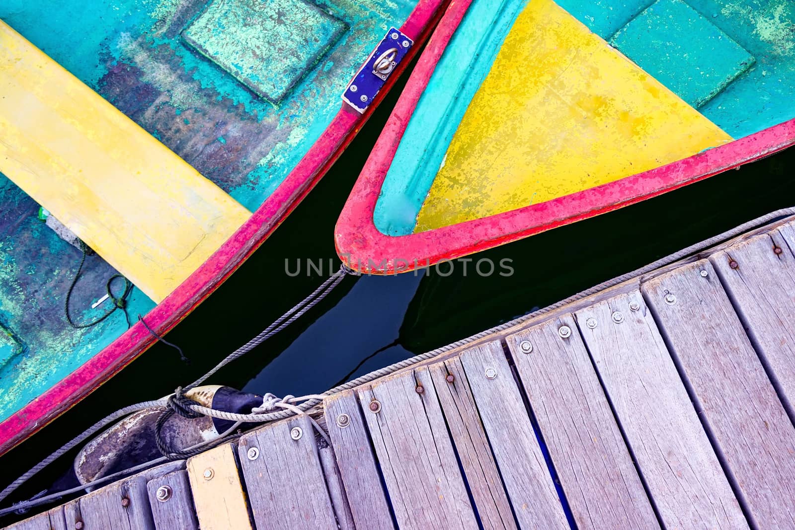 The colorful recreational boats and wooden pier from top view angle