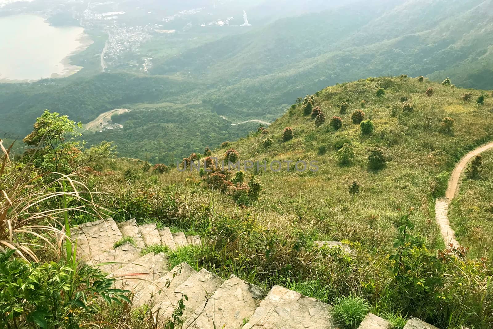 The village, green grass, plants, footpath and stone staircase in mountain