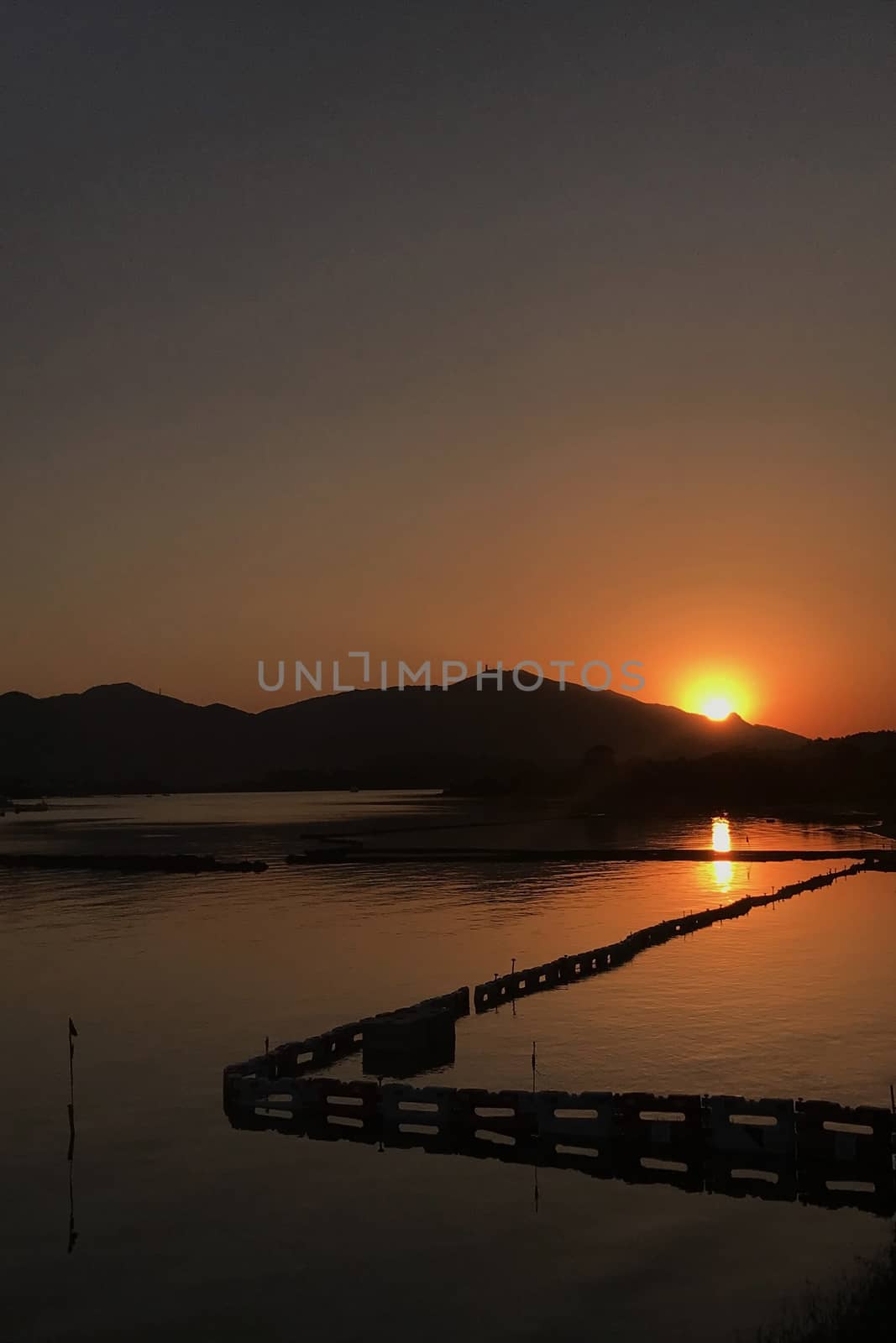 The vertical silhouette of mountain and ocean at sunset