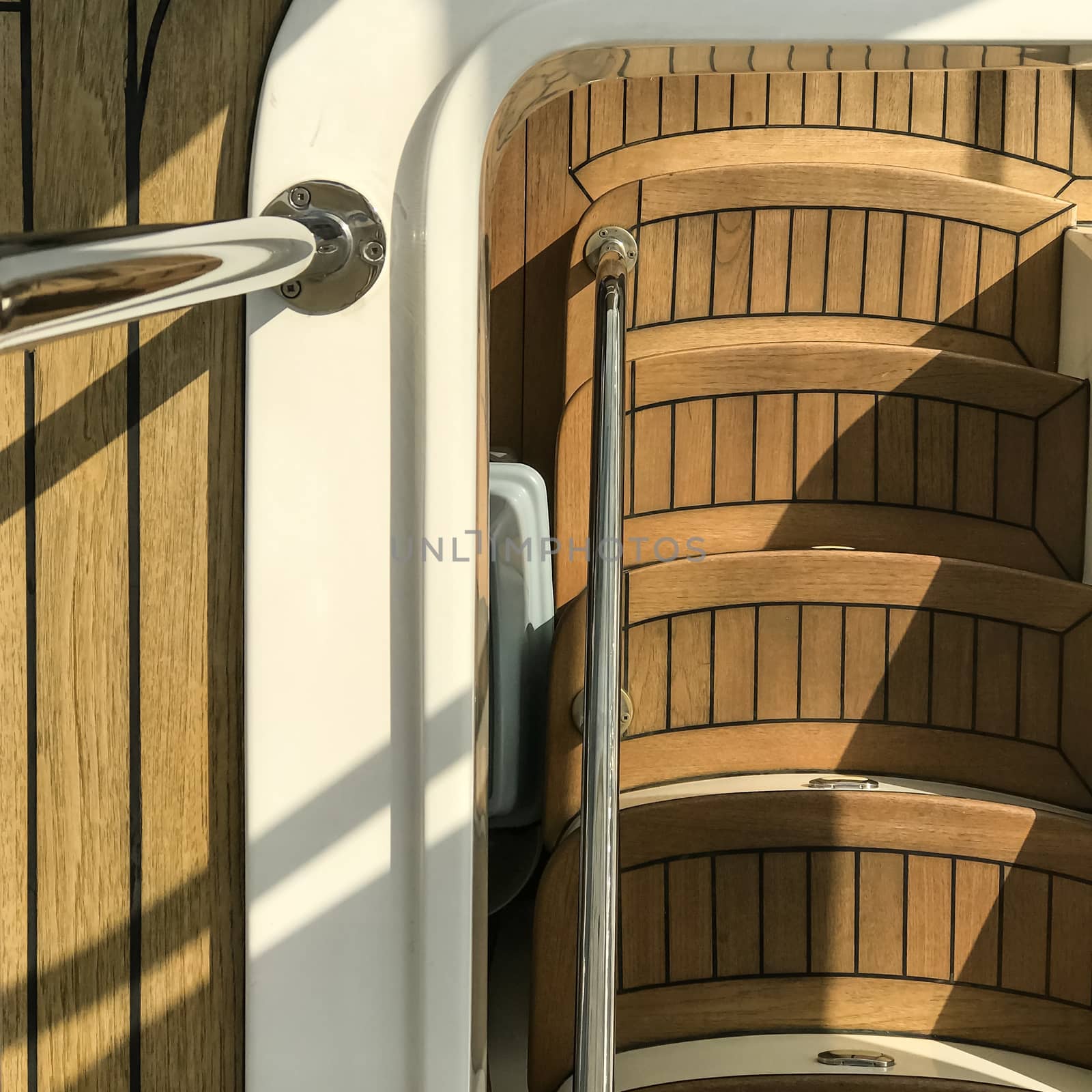 wooden staircase in the white yacht with the sunlight and shadow