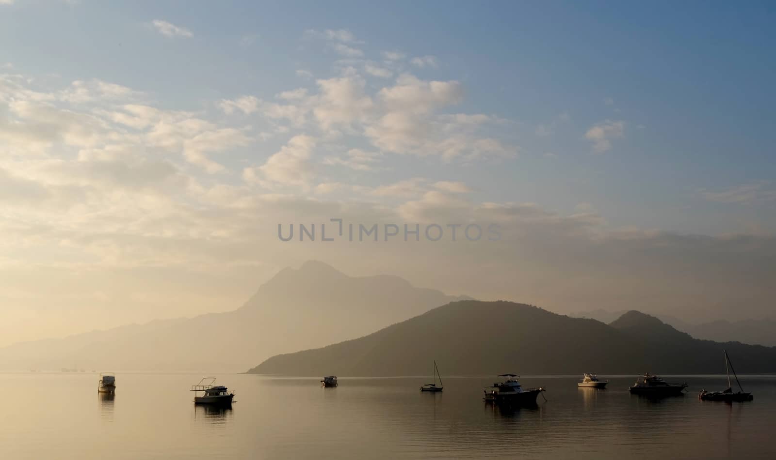 The foggy sunrise landscape photo with boat, mountain in the morning