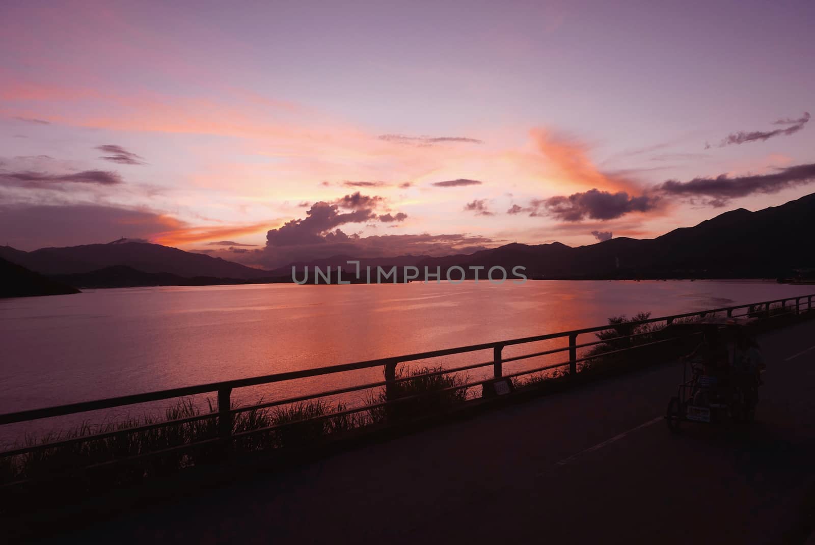 mountain, footpath fence and the sea at sunset