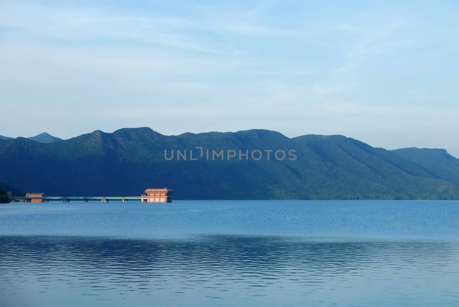 Building in the reservoir, sky, and mountain