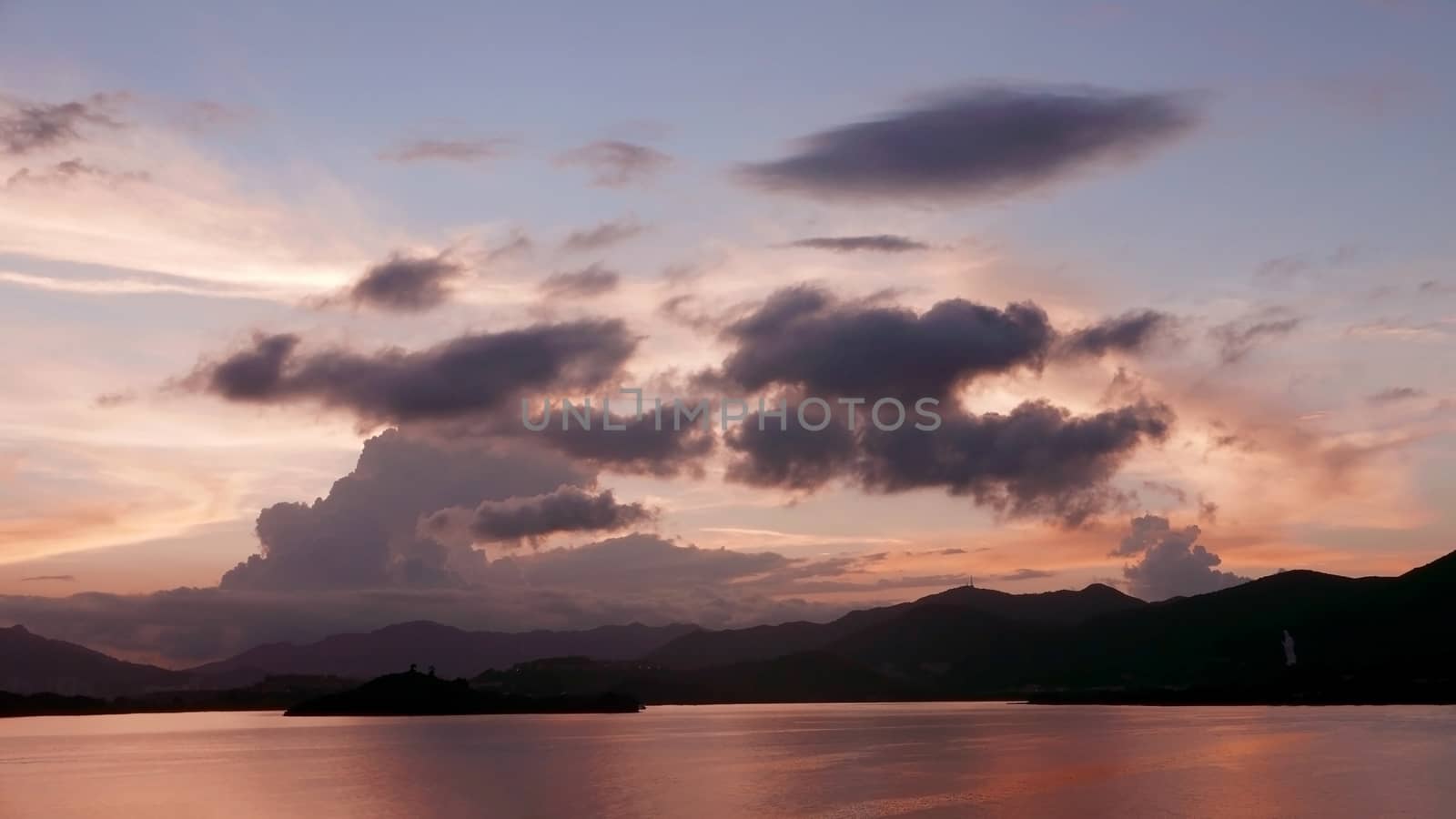 The silhouette of mountain, ocean and the dramatic cloud at sunset