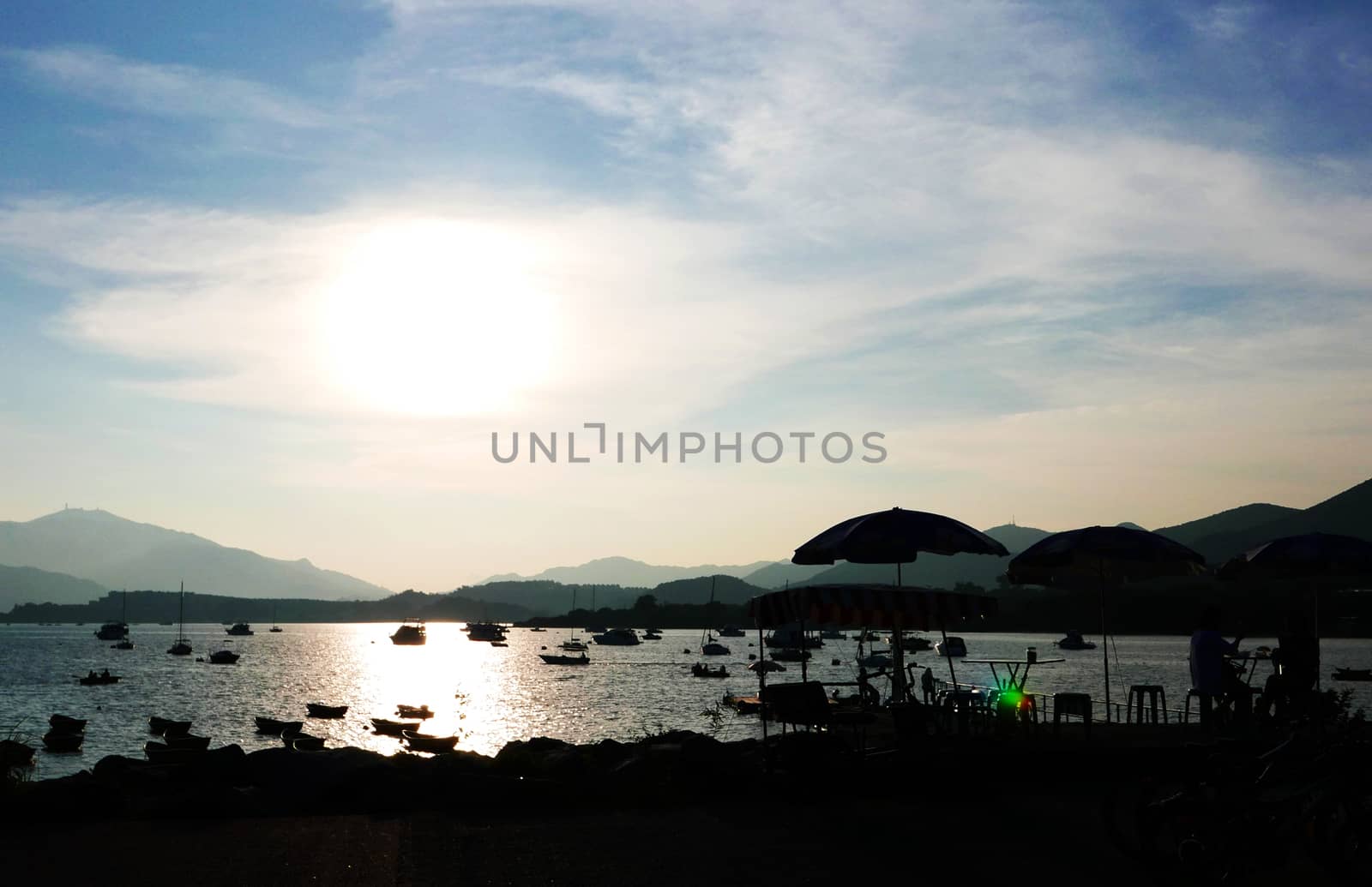 The Silhouette of fishing boat on the lake and the blue sky