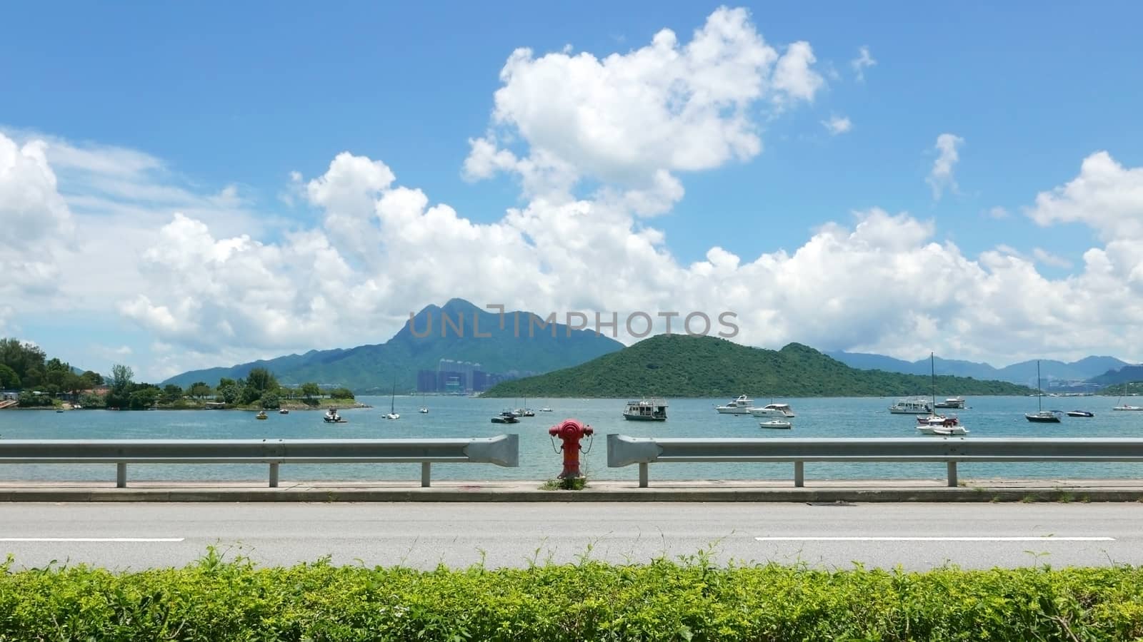 Road, red water pump, boat, tree, lake, blue sky and the white cloud