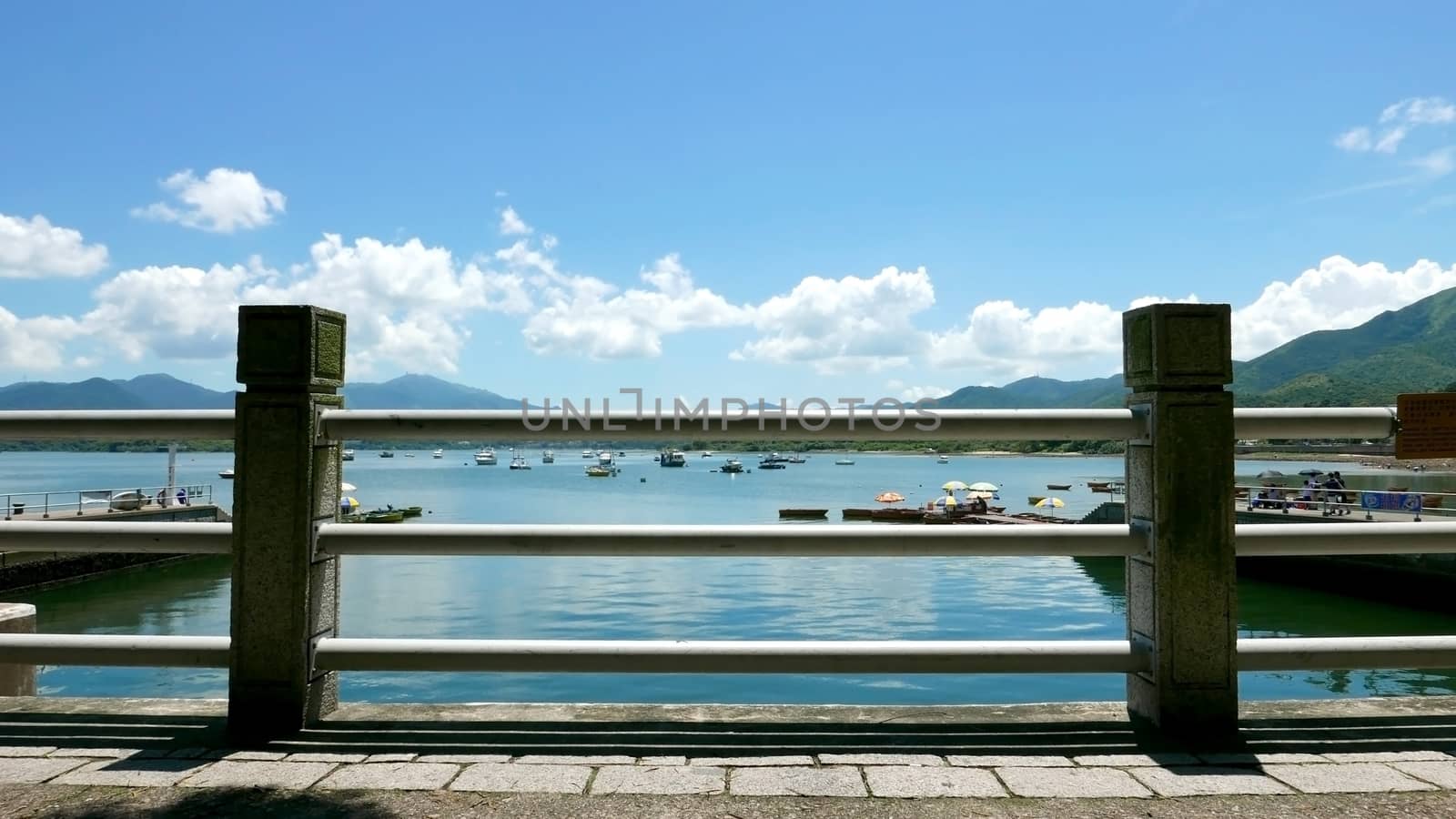 Boats, pier, lake and the white cloud in sunny day