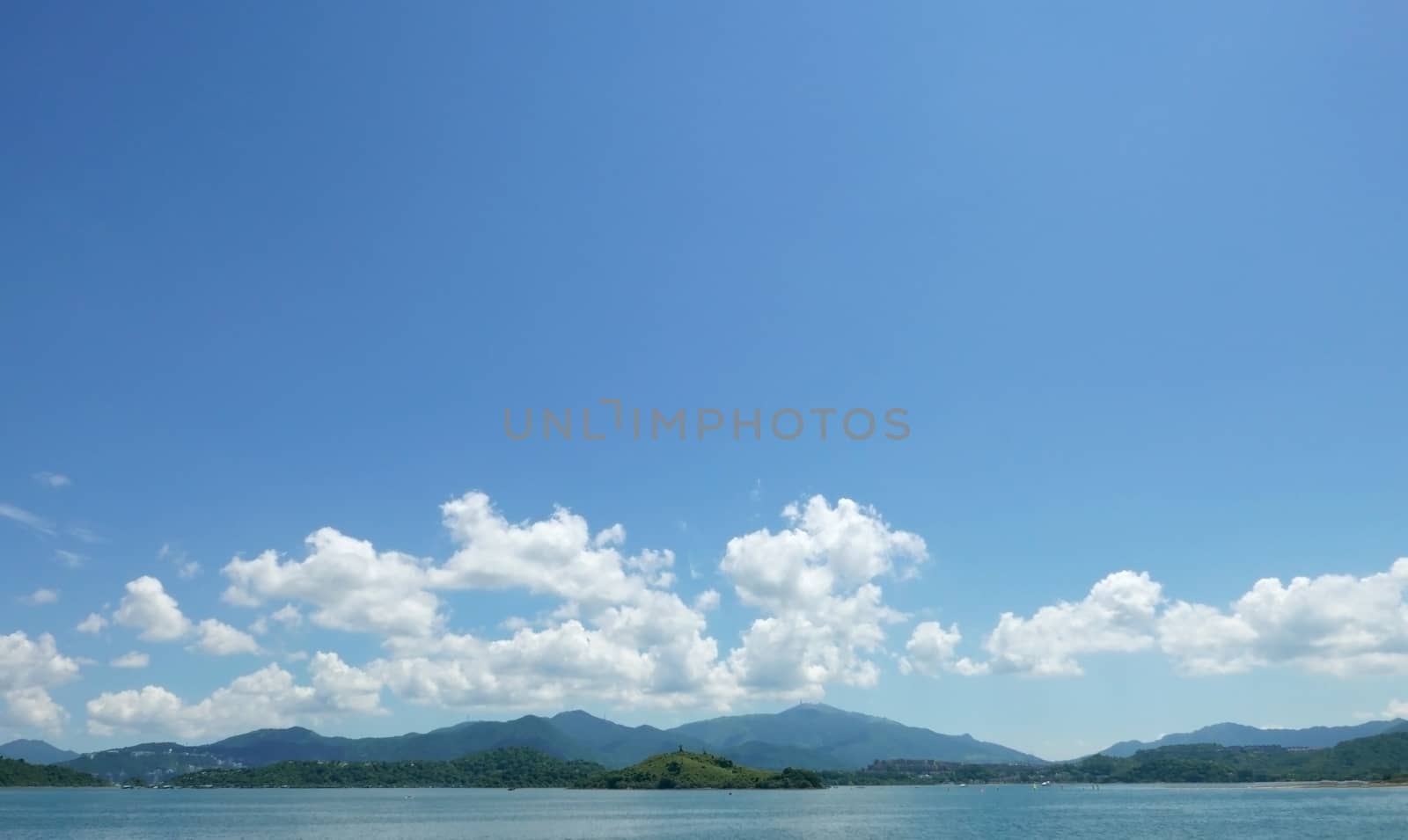 Green mountain, lake, blue sky and the white cloud