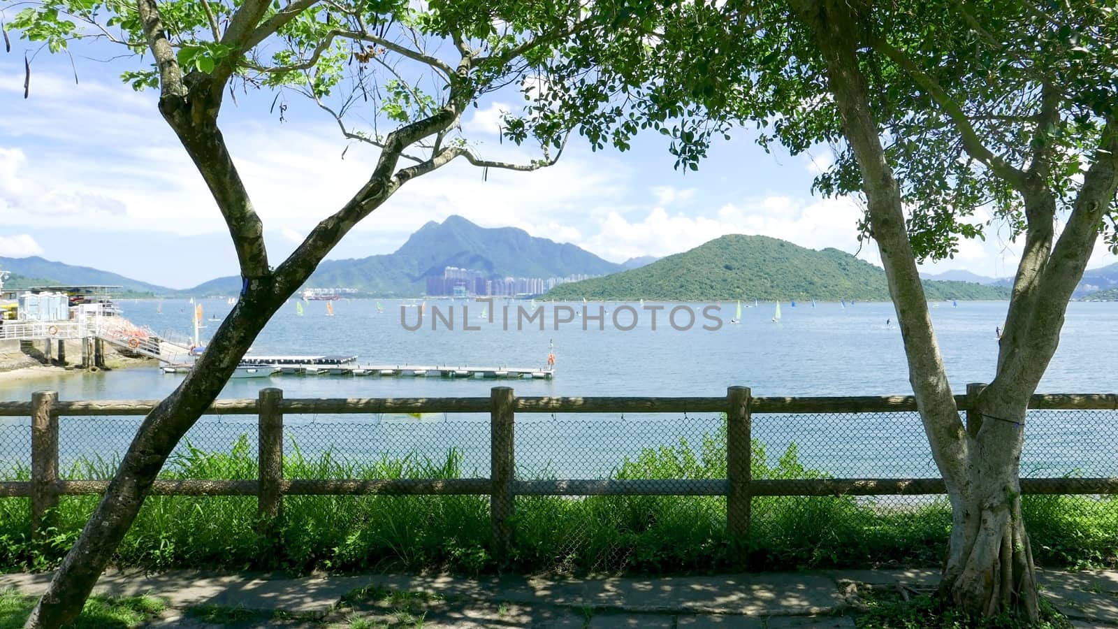 Outdoor wooden fence, mountain and watersport wind surfing in the sea