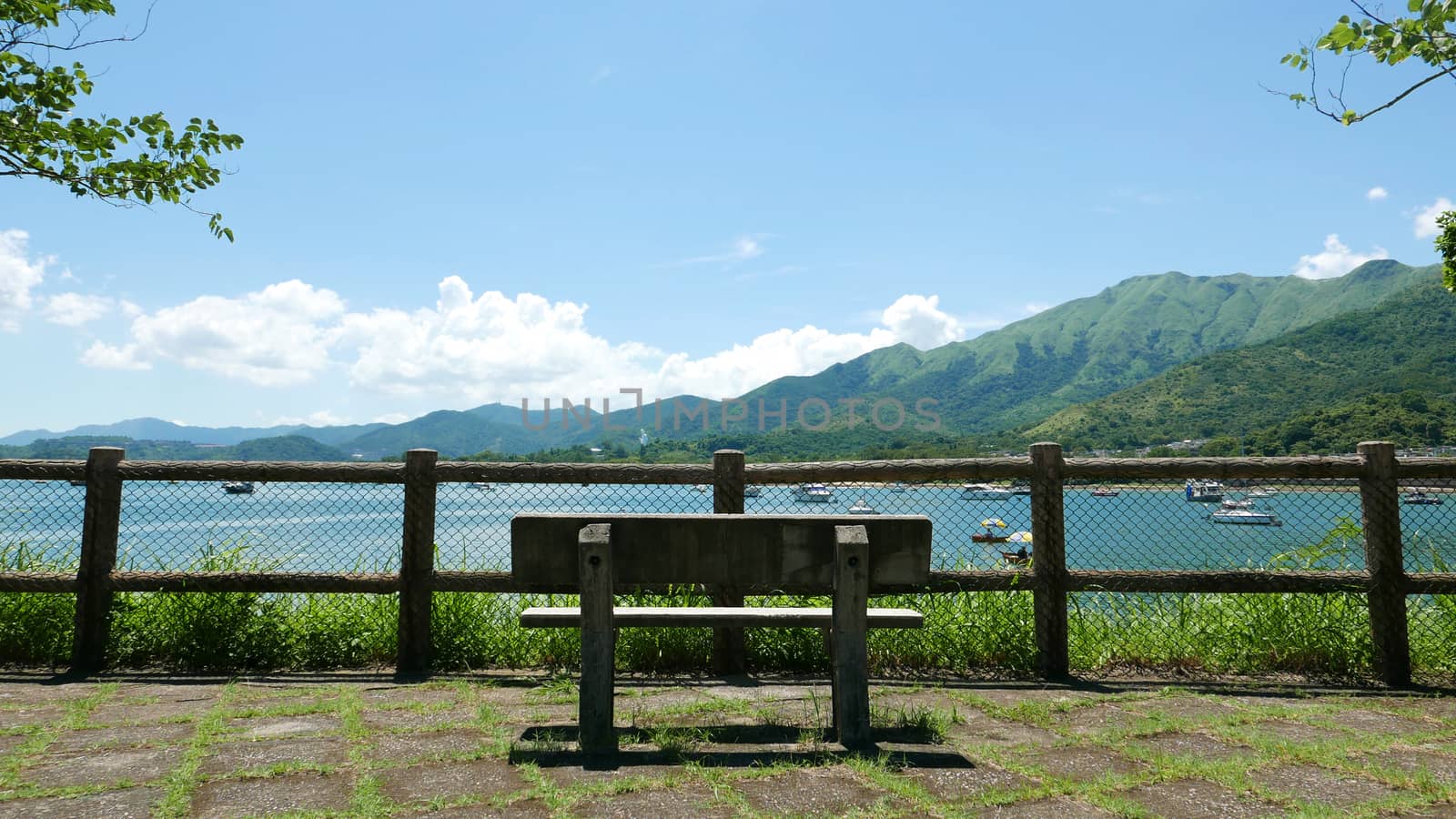 Outdoor wooden fence, bench, mountain and the motorboats