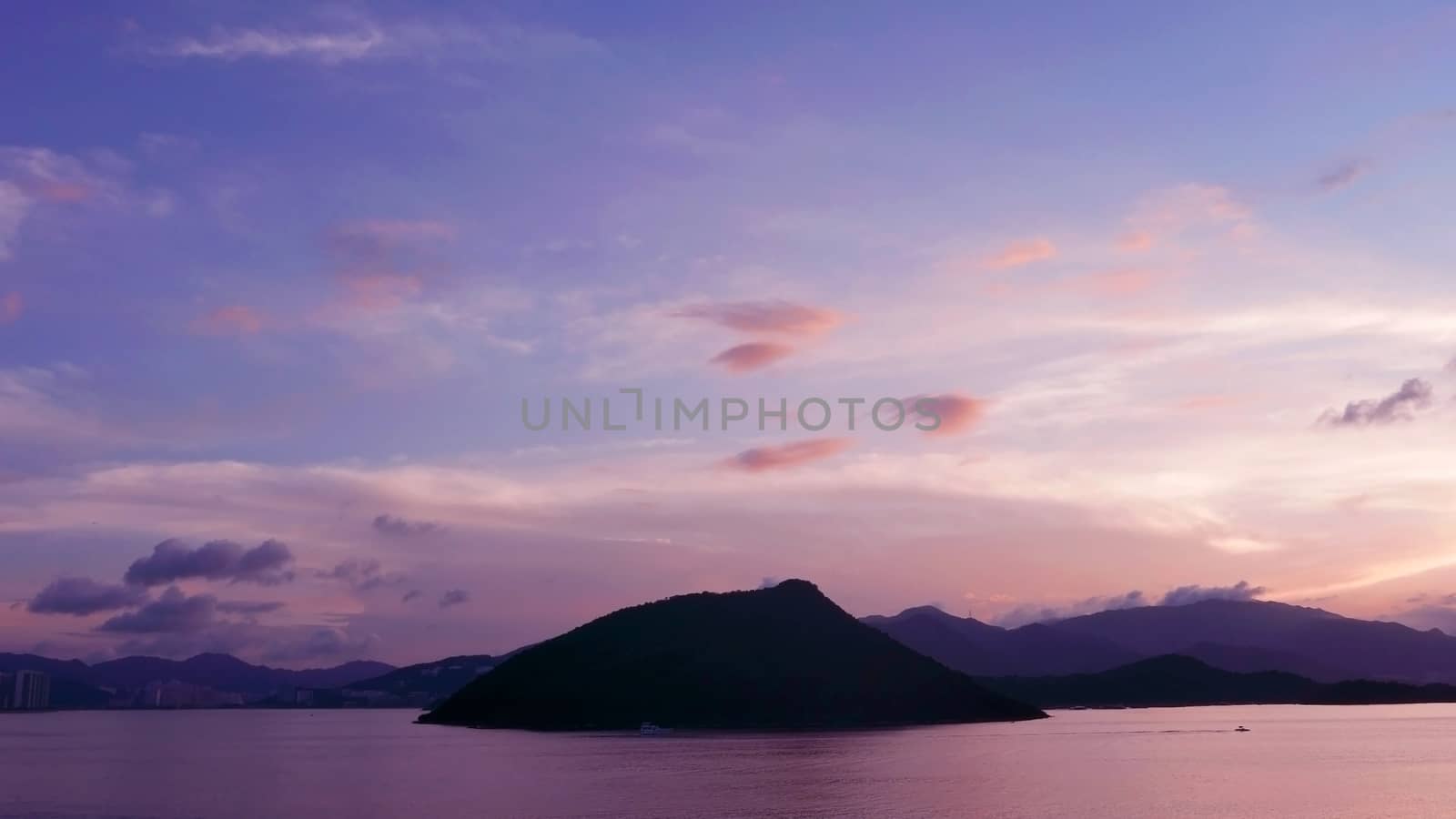 mountain, dramatic sky, boat on the sea at sunset