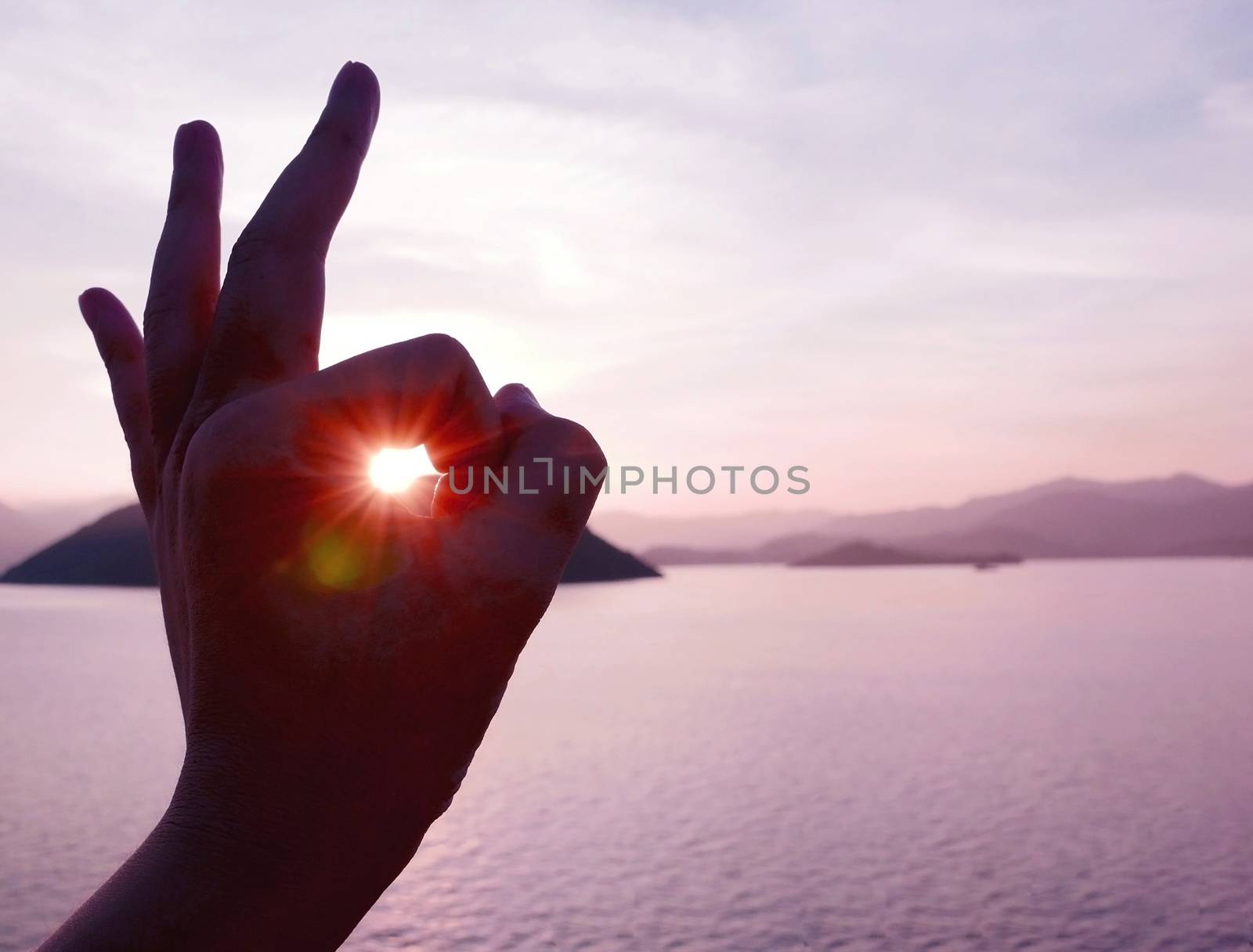 The sunlight is from human hand with mountain and the sea