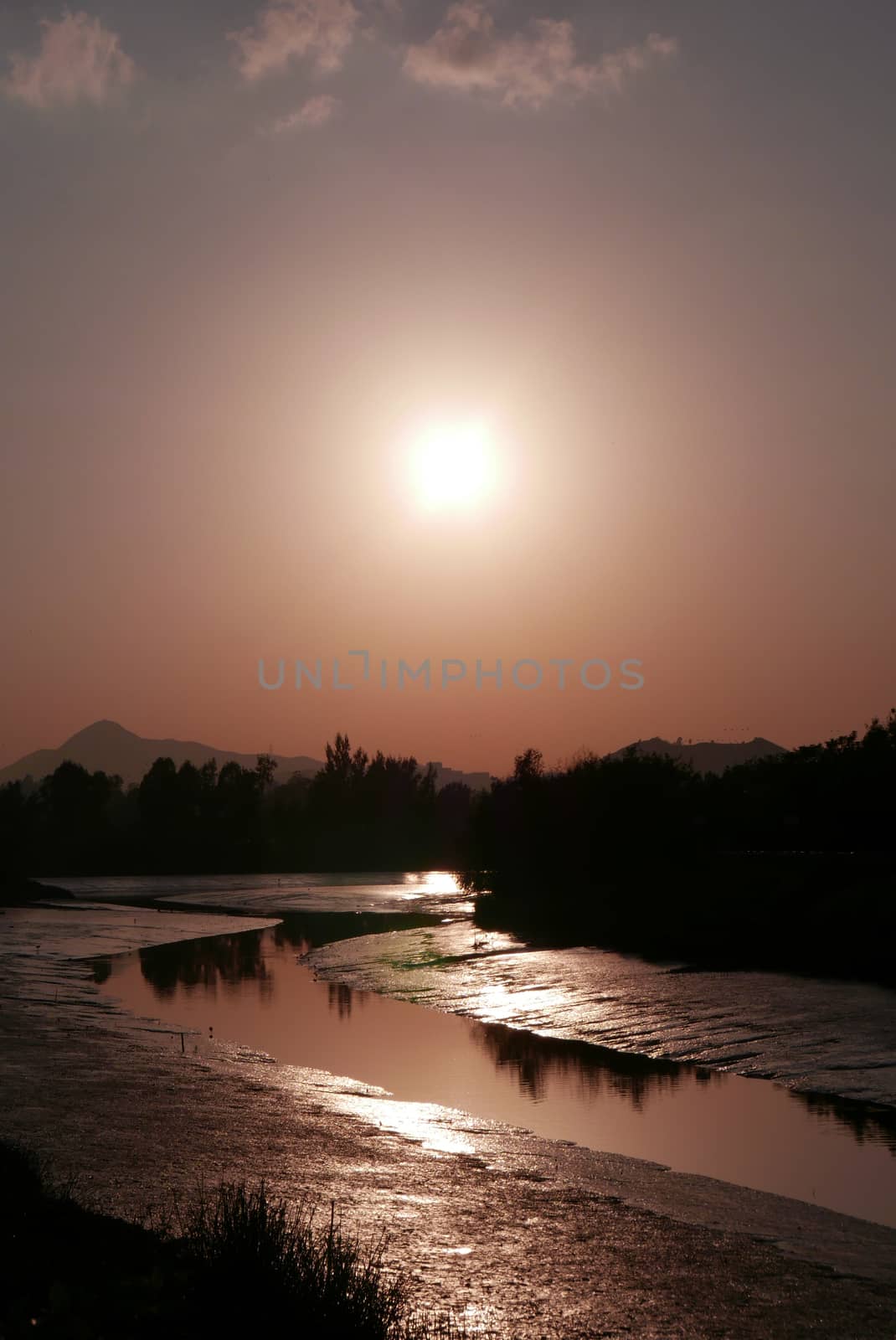 Silhouette of tree, mountain and river at sunset by cougarsan