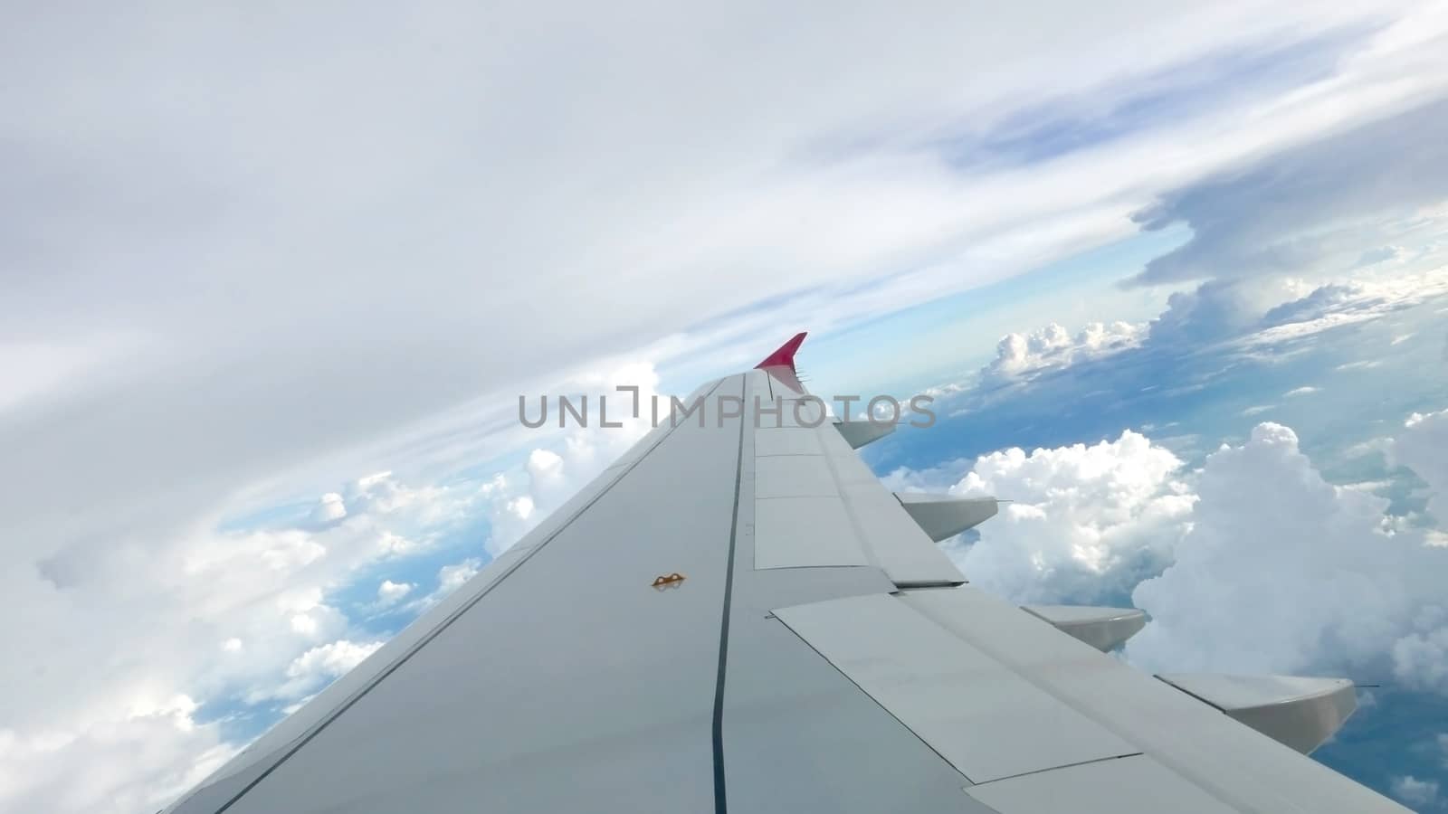 Blue sky cloudscape background and the wing of airplane 