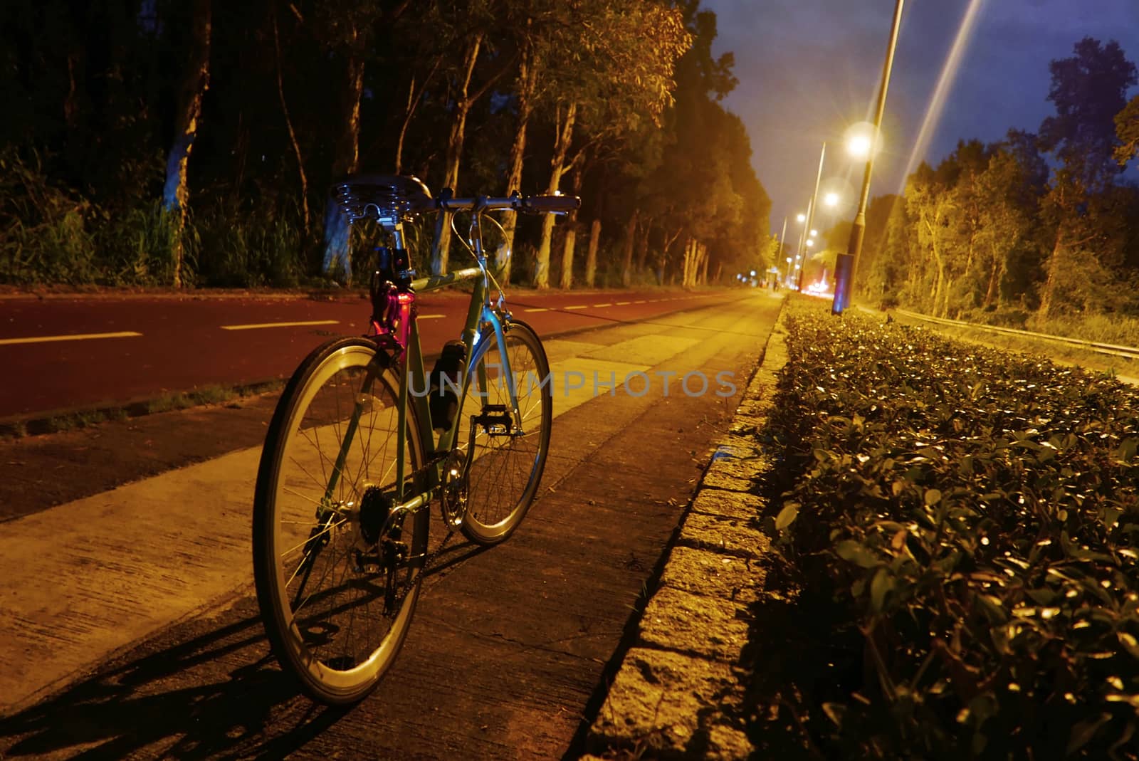 Classic parked bicycle near road at night by cougarsan