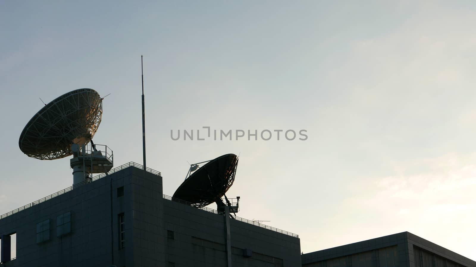 Few satellite dishes on roof top building with the blue sky