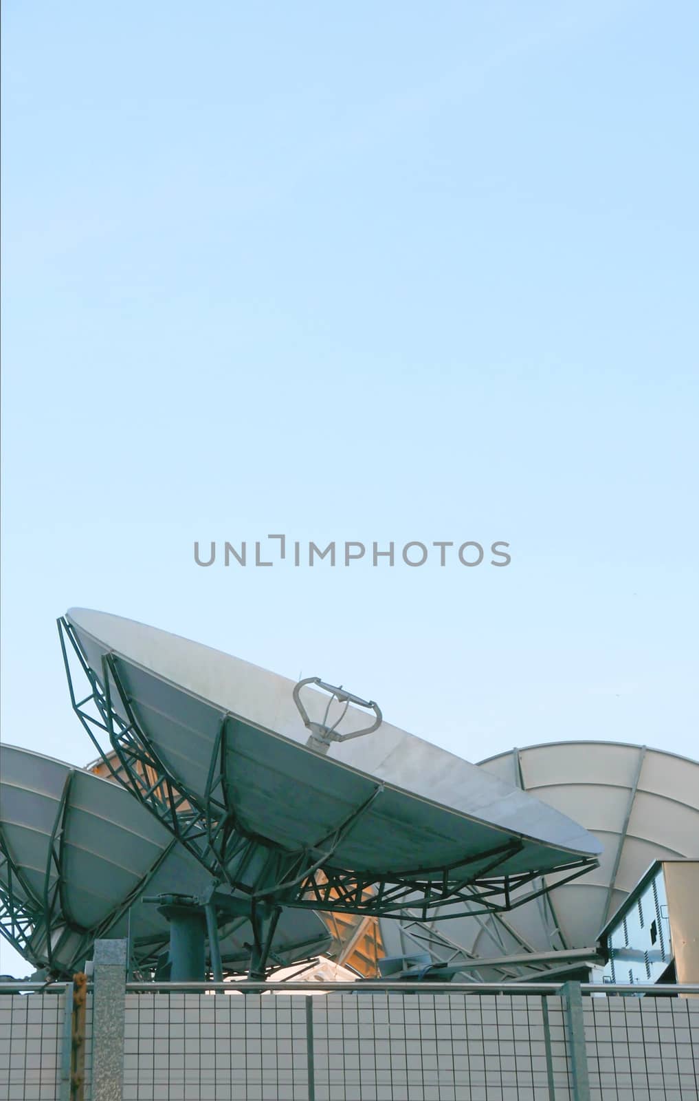 Few satellite dishes on roof top building with the blue sky