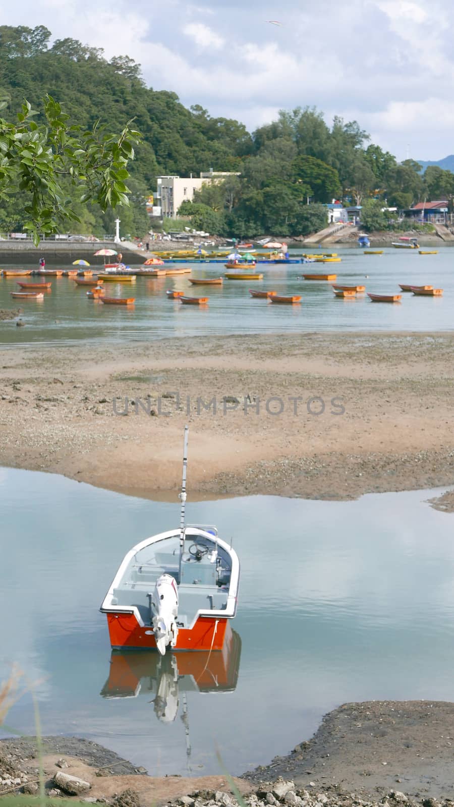 red fishing boat on peaceful lake in day time