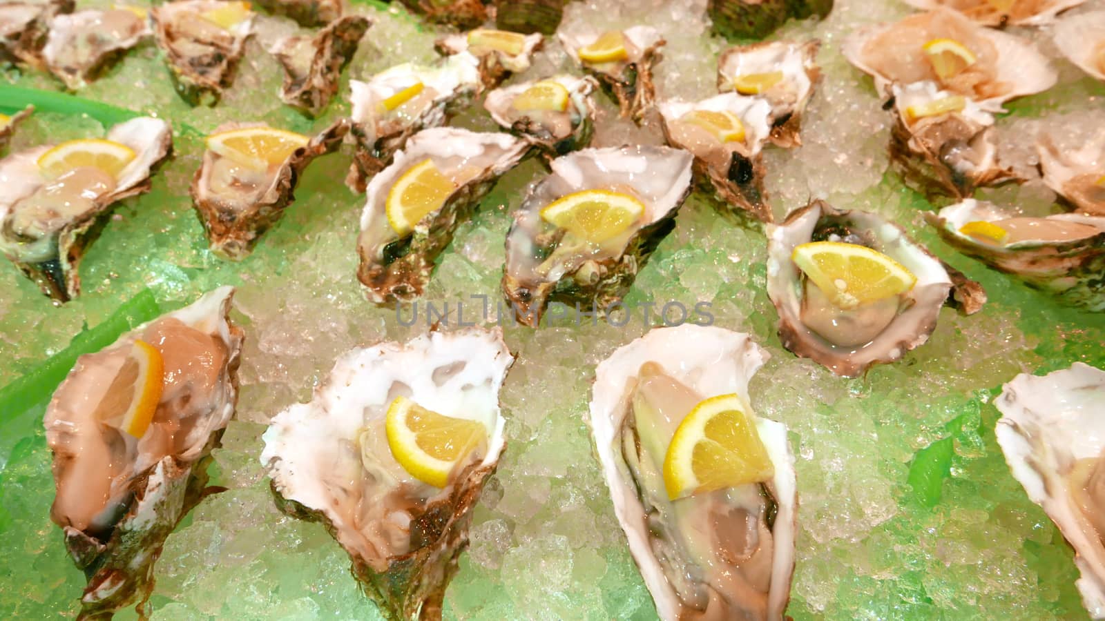 Some oysters are on the ice tray with lemon